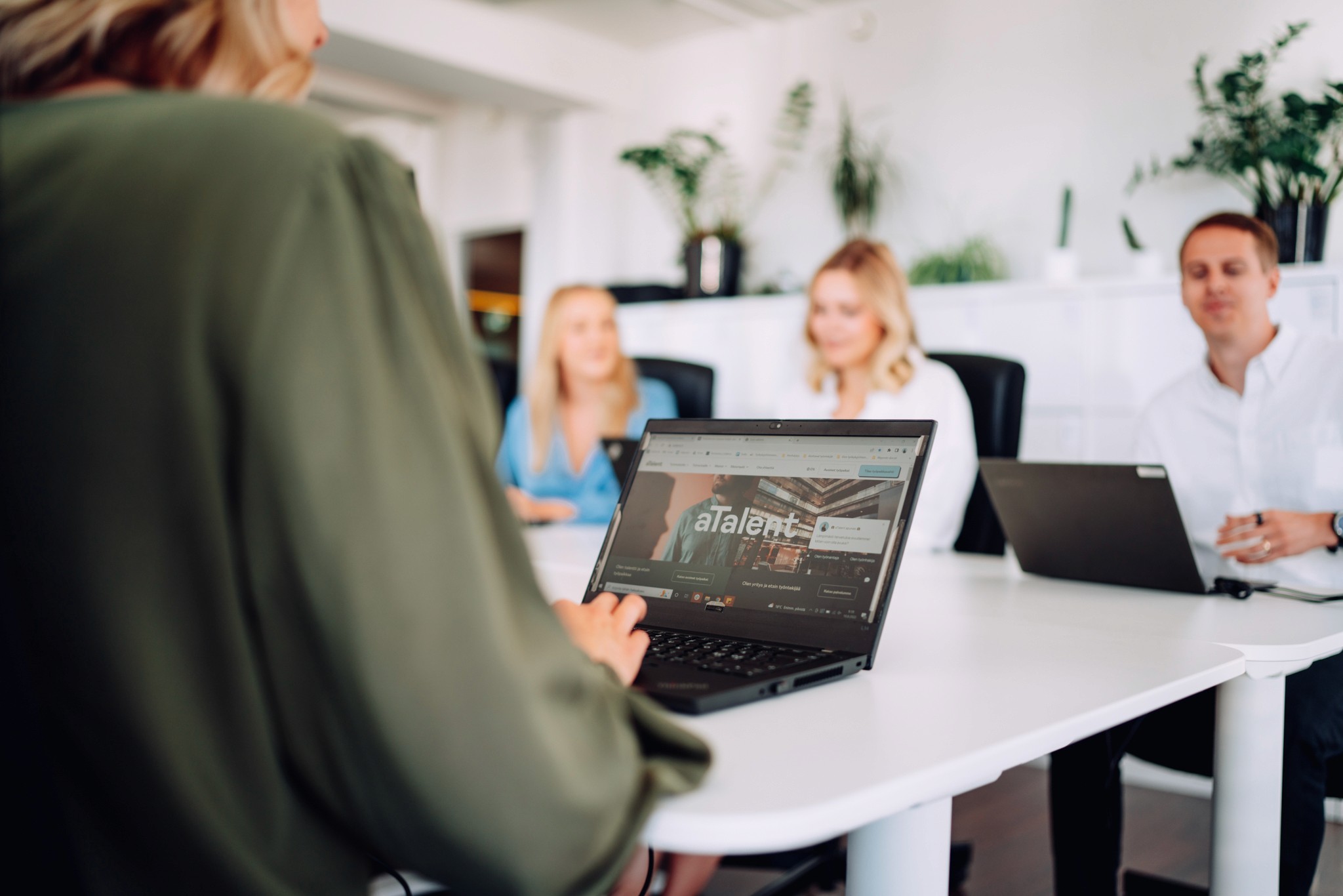 Laptop displaying "atalent" website in a meeting