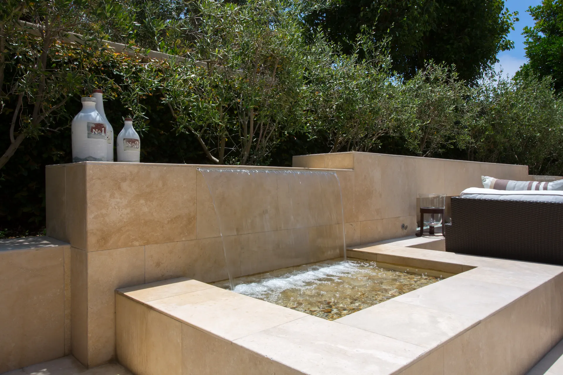 Tranquil garden fountain with decorative vases in a serene outdoor setting, Newport Beach Remodel.