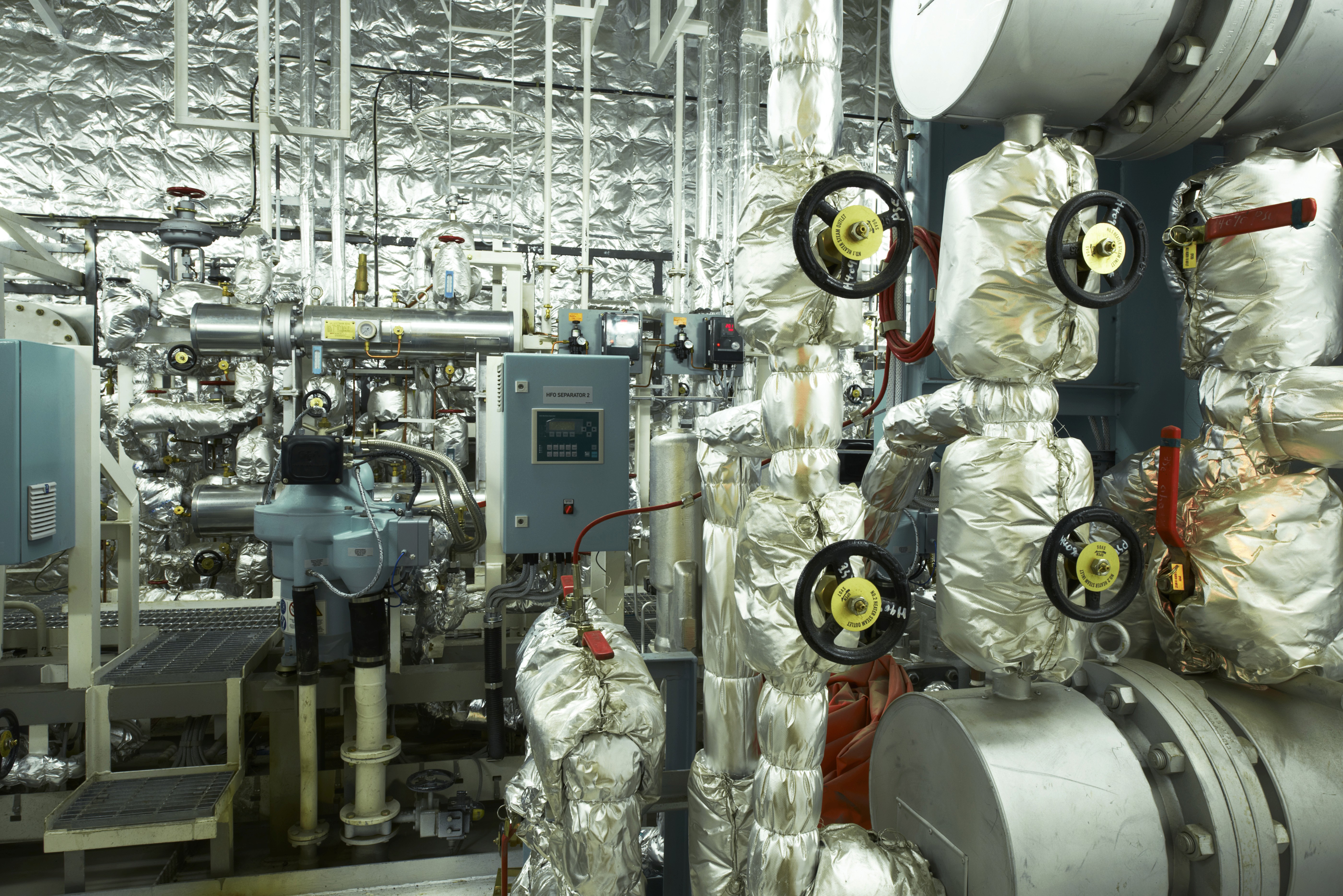 Reflective bubble foil insulation wrapped around HVAC ductwork in a crowded mechanical room