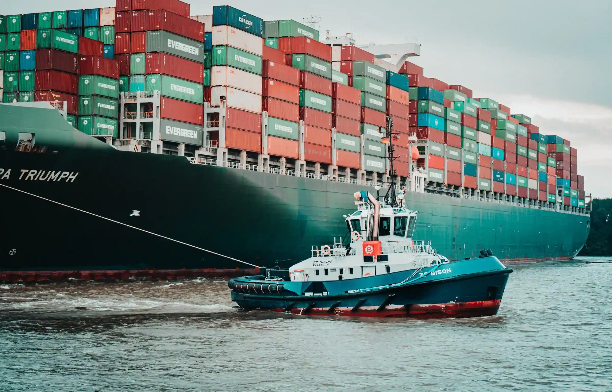 Containerhafen mit Schiff und Schlepper – Illustration zu Transportemissionen und Lieferkettenmanagement