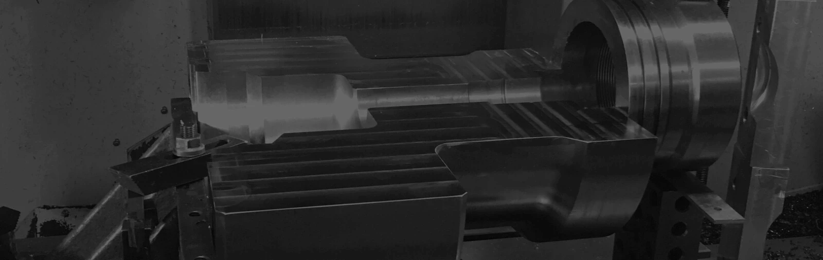 Modern glass and wood cabin with a cozy outdoor deck featuring wicker furniture, surrounded by lush green trees and a serene forest setting.