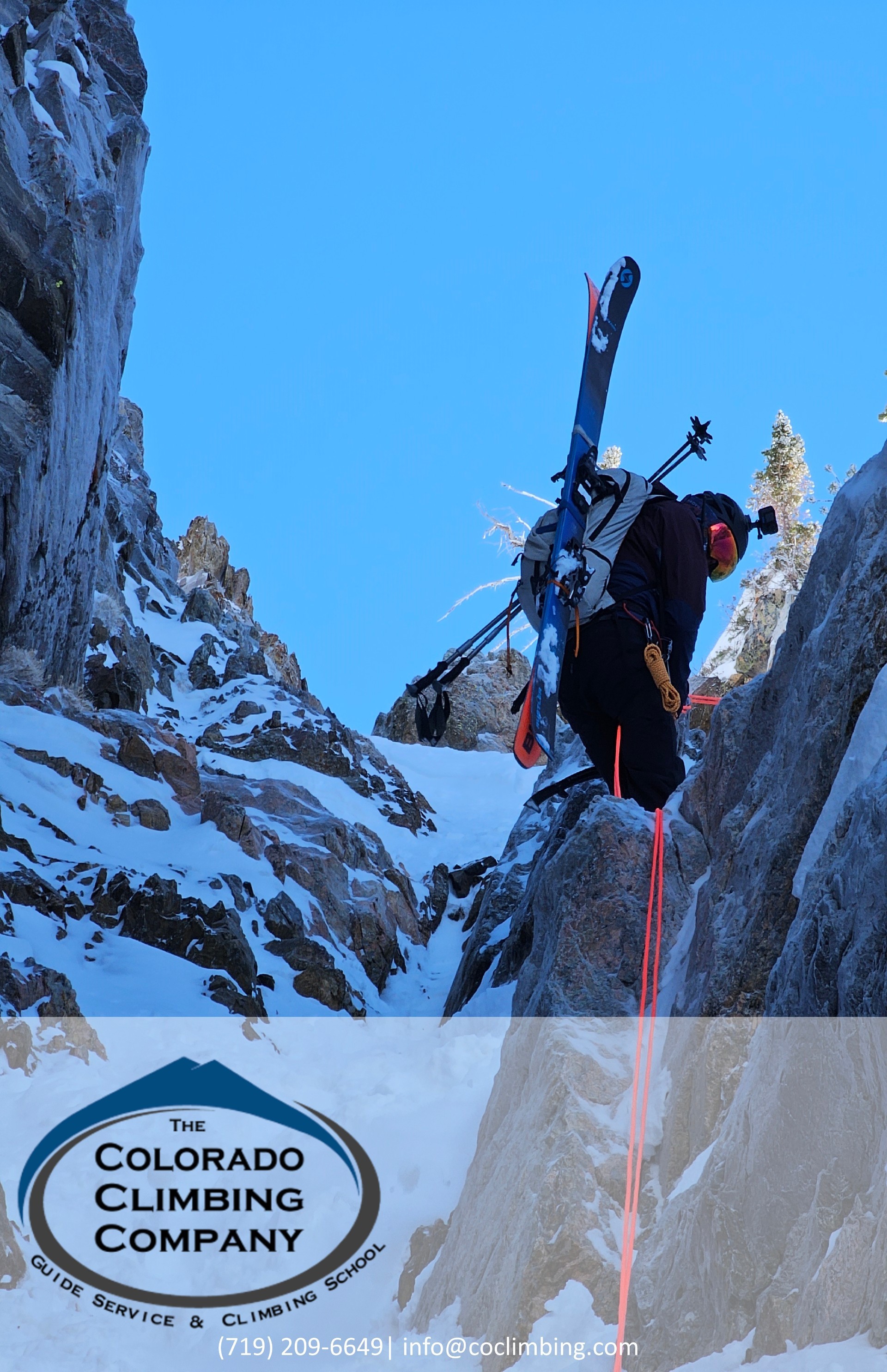 Skier rappels into couloir with skis on their back