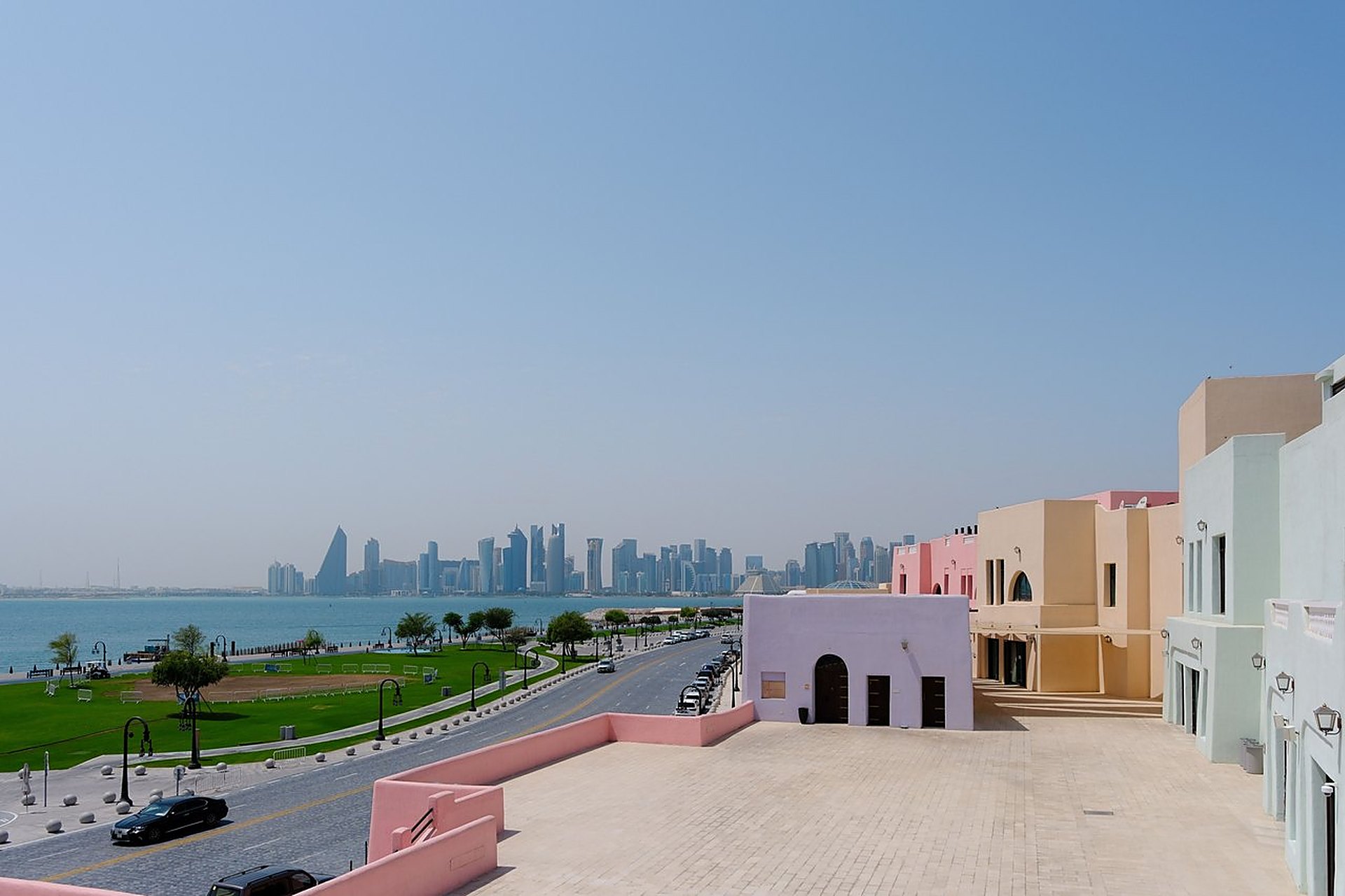 Les façades pastel du quartier de Mina, à Doha, au bord de la Corniche, avec les tours de West Bay au loin, une ville d'où l'on rejoint les siens le jour même