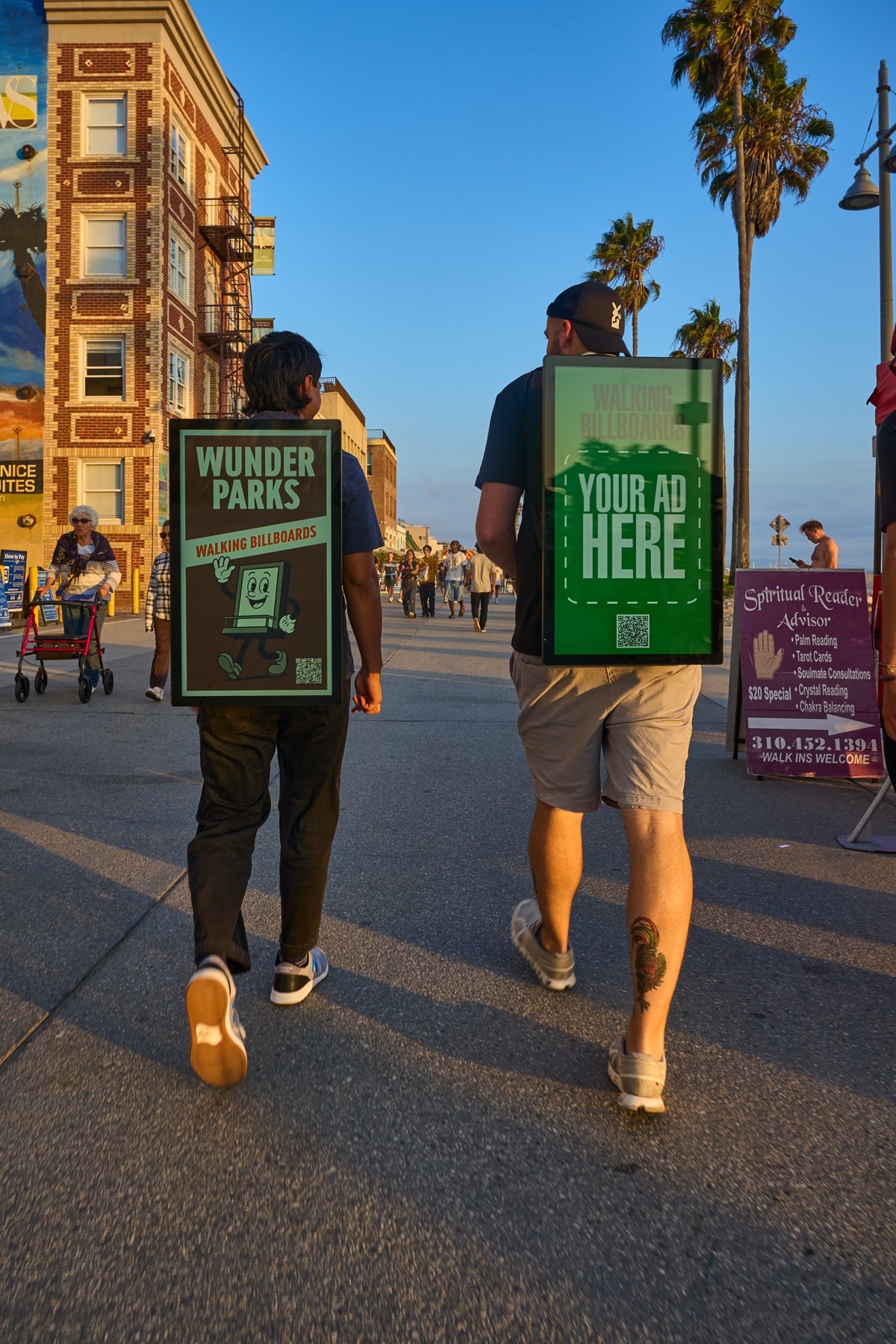 Two Wunderparks carriers walking a sunlit pedestrian boardwalk