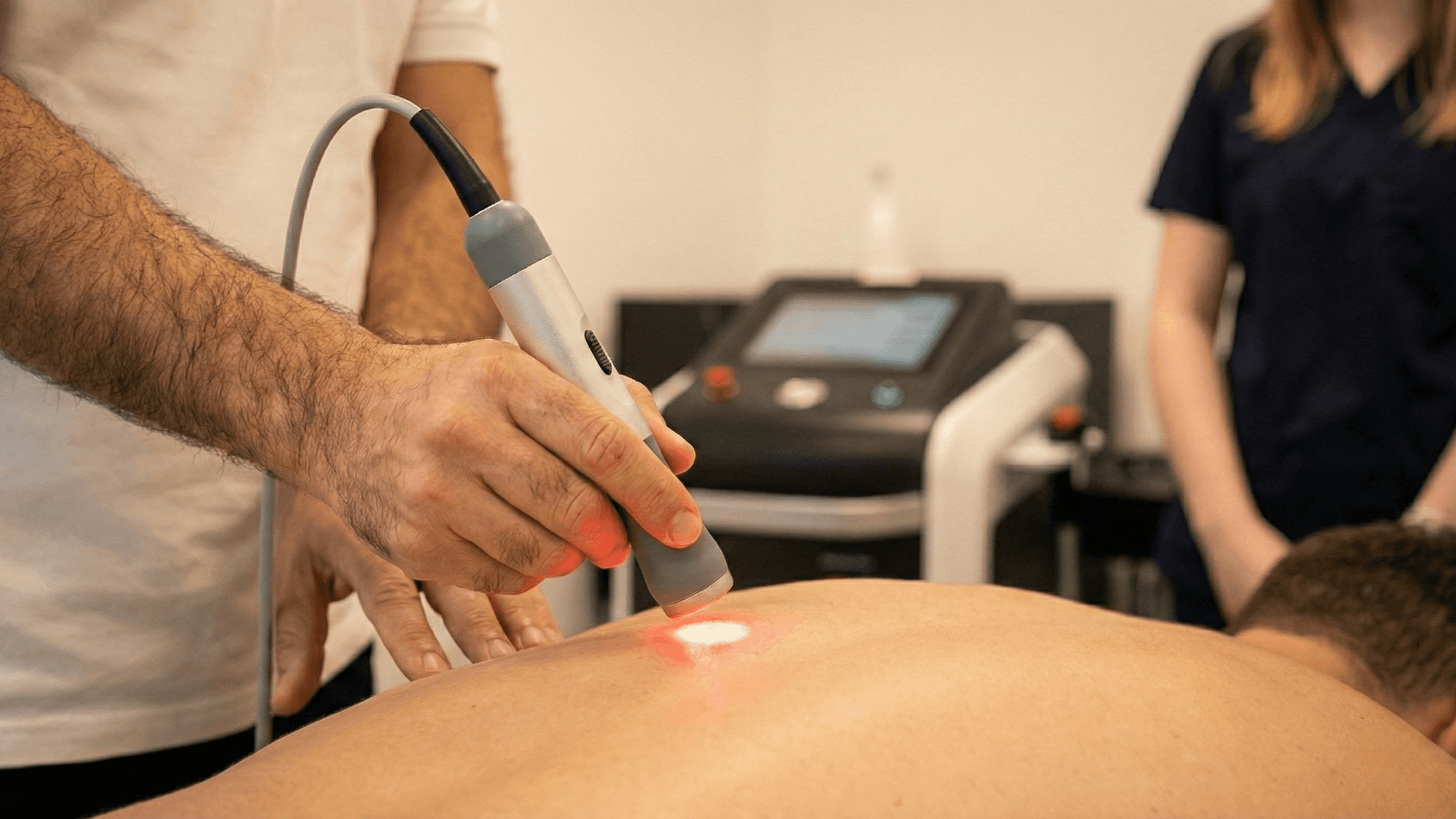 woman in orange long sleeve shirt sitting beside table with macbook pro
