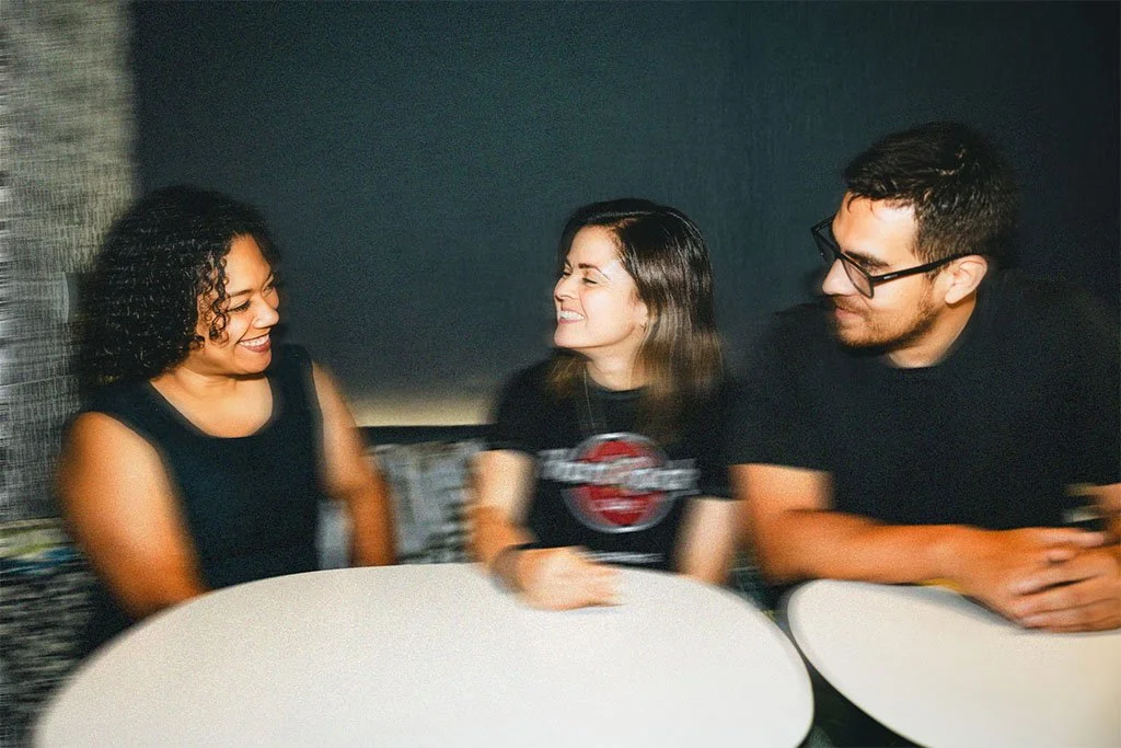 Tres personas riendo en un café
