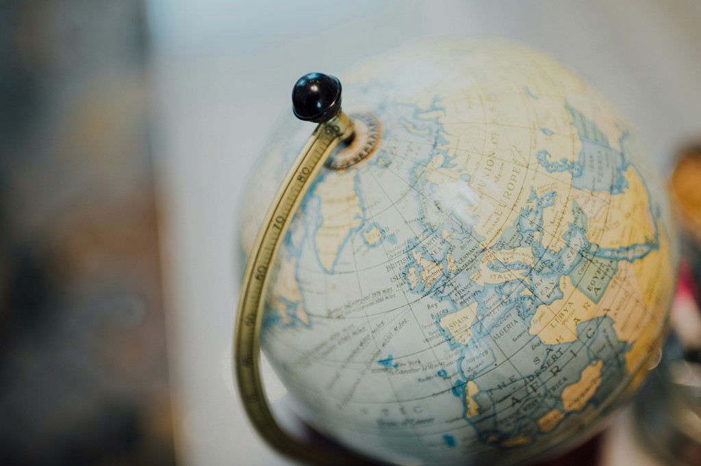 Close-up of a globe with a black mounting point, showing geographical details and textures.