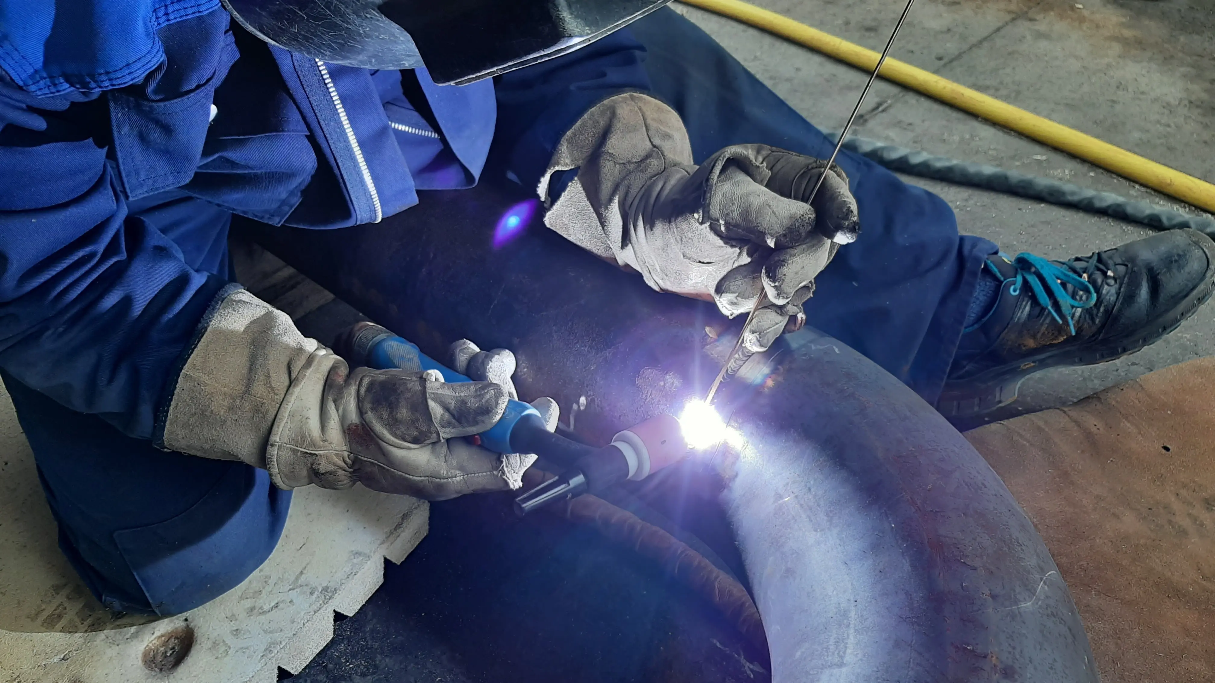 Technicien en train de souder des tubes de calorifuge