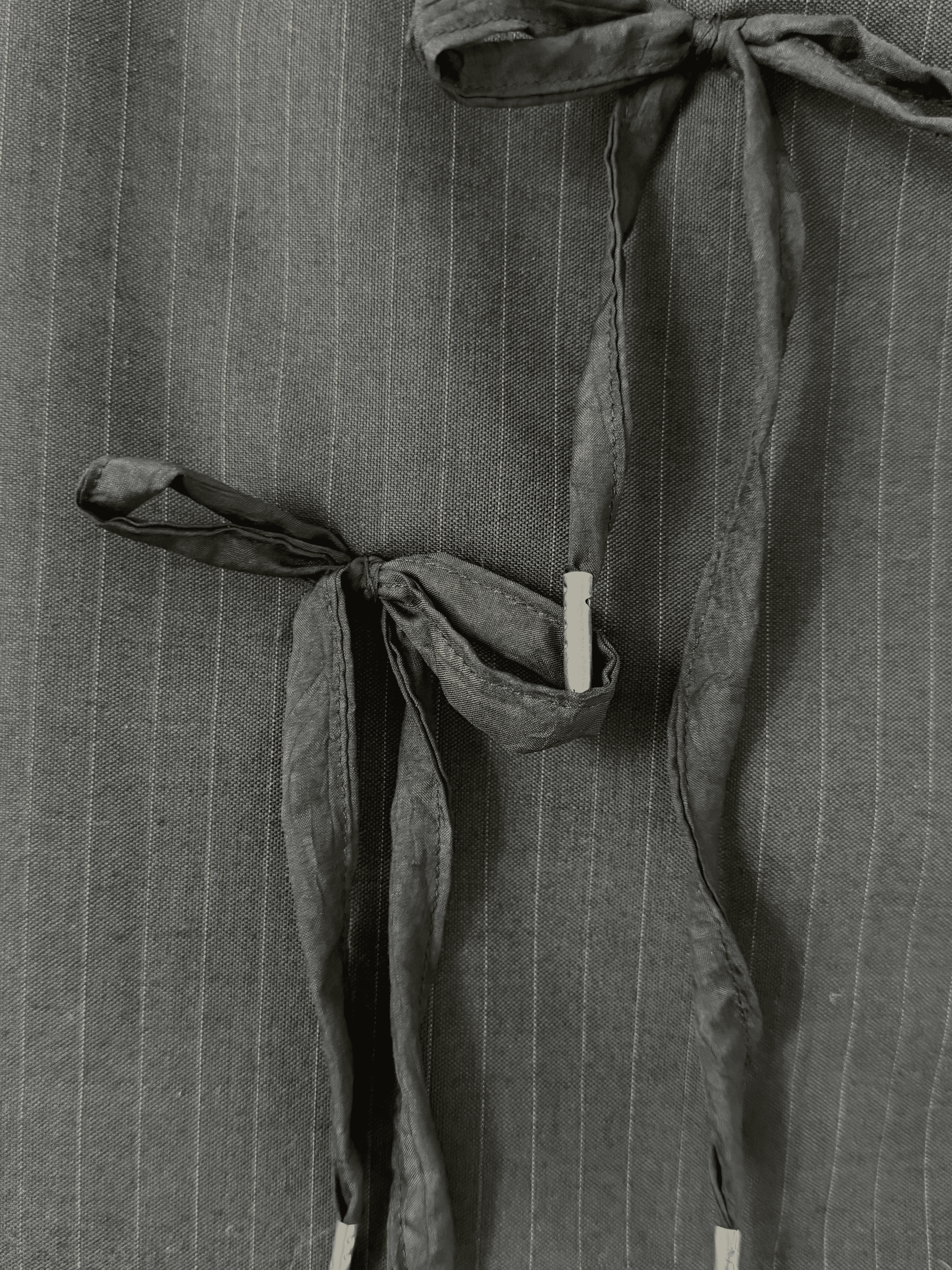 Close up of mini black pinstripe skirt with tie detailing