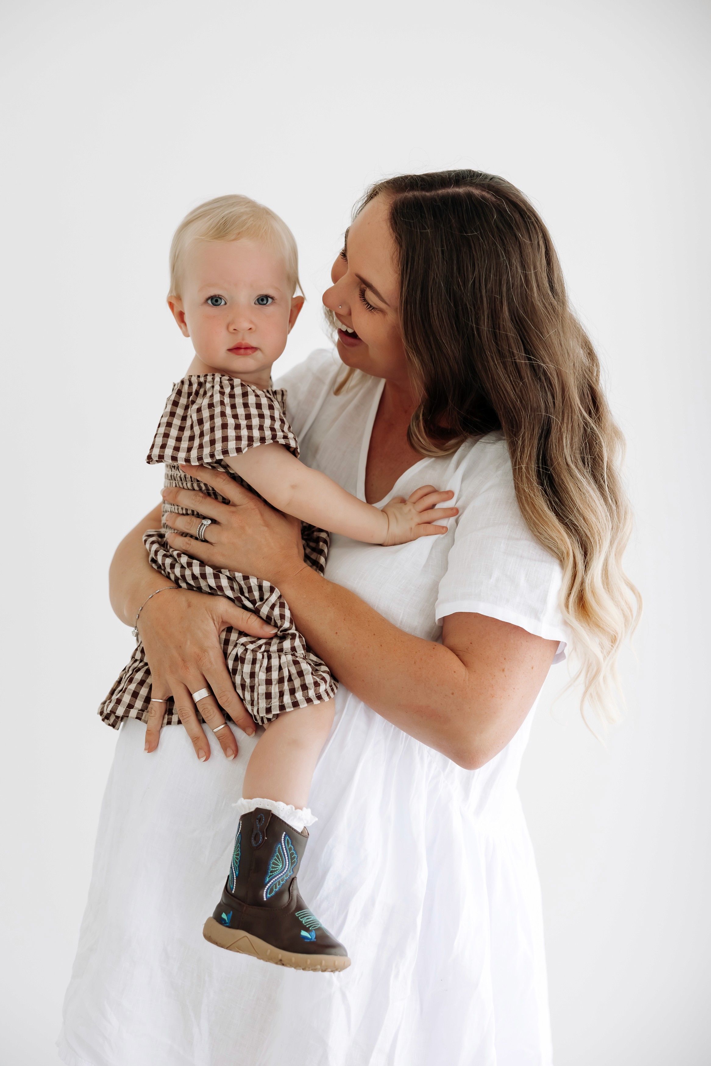 Pregnant mother holding daughter during a studio motherhood photography session in Mackay