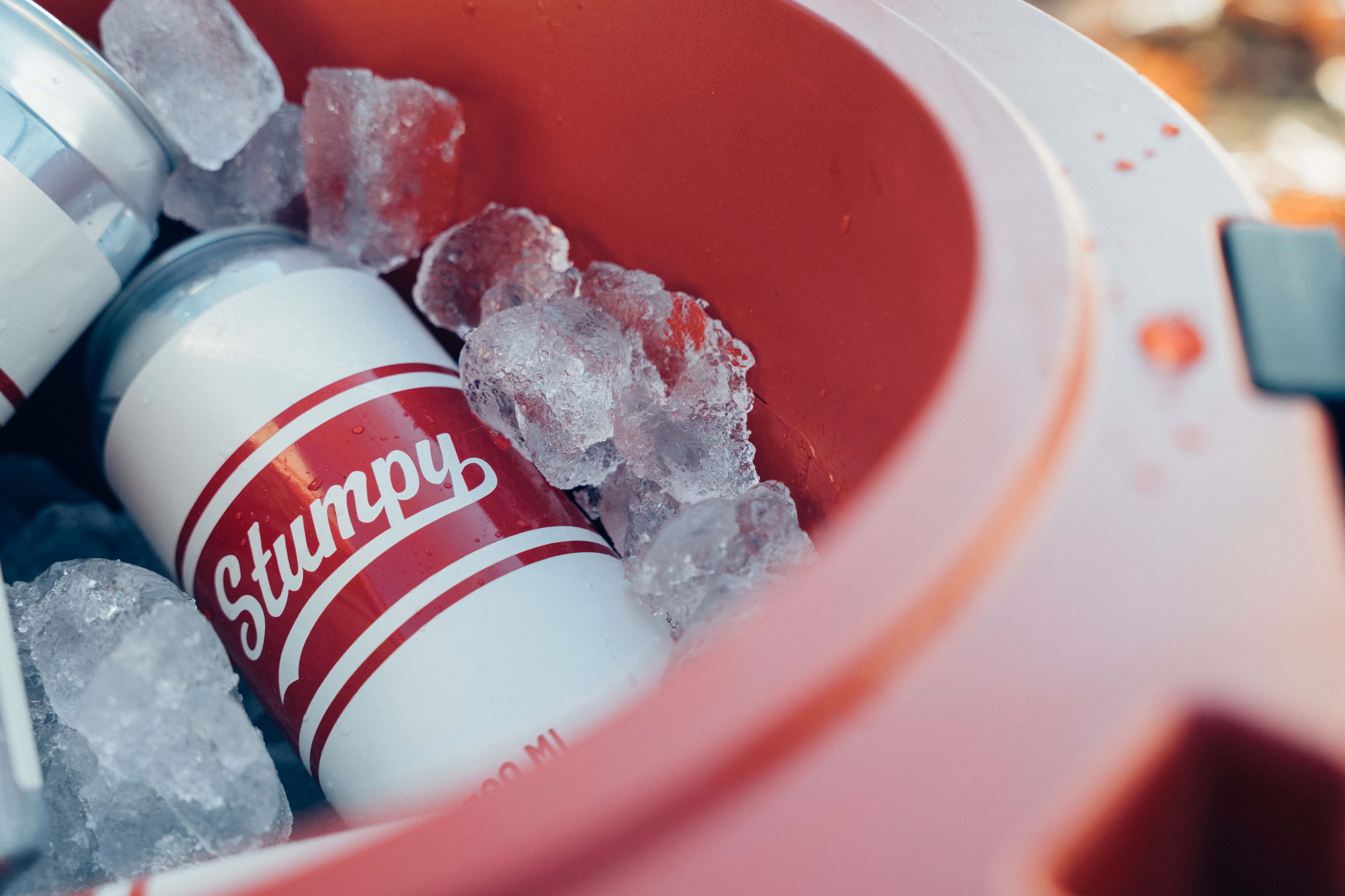 A cold beer surrounded by ice inside the stumpy cooler
