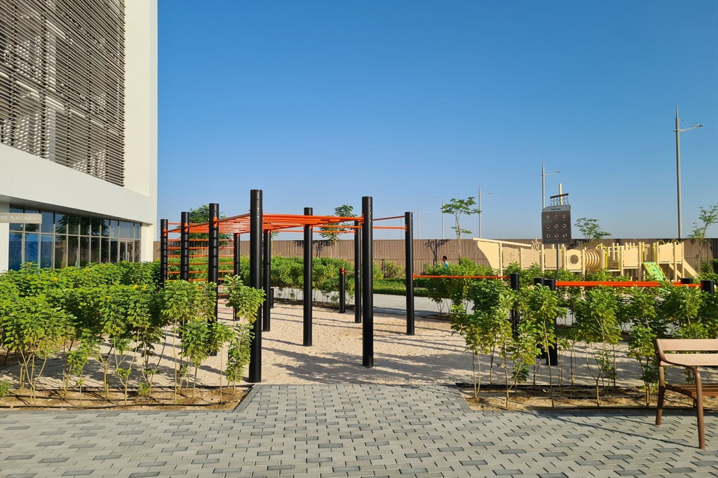 Dubai Maritime City park showcasing vibrant gardens, pathways, and contemporary buildings, ideal for relaxation and leisure.