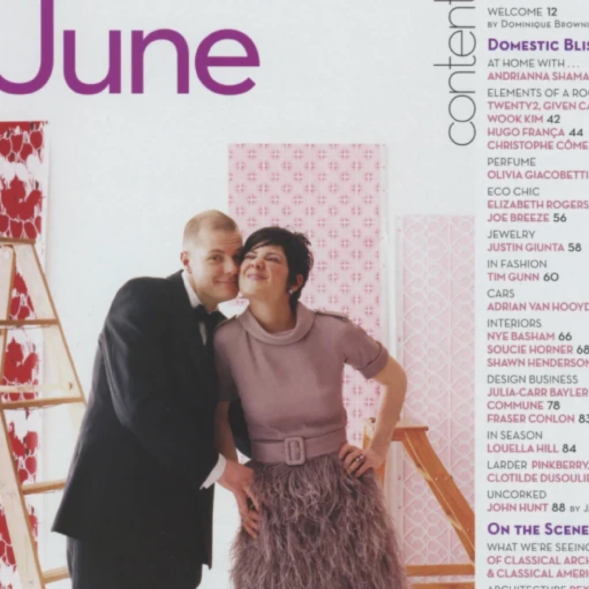 Kyra and Rob Hartnett posing cutely in front of rolls of their screen printed wallpaper.