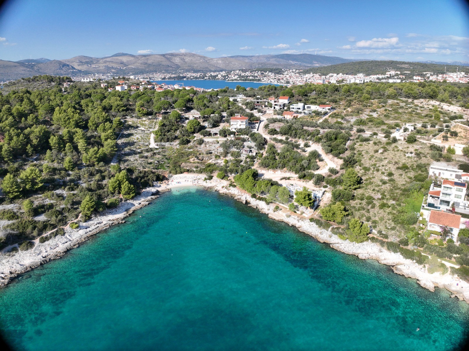 Architectural modern house with angular walls and infinity pool at sunset.