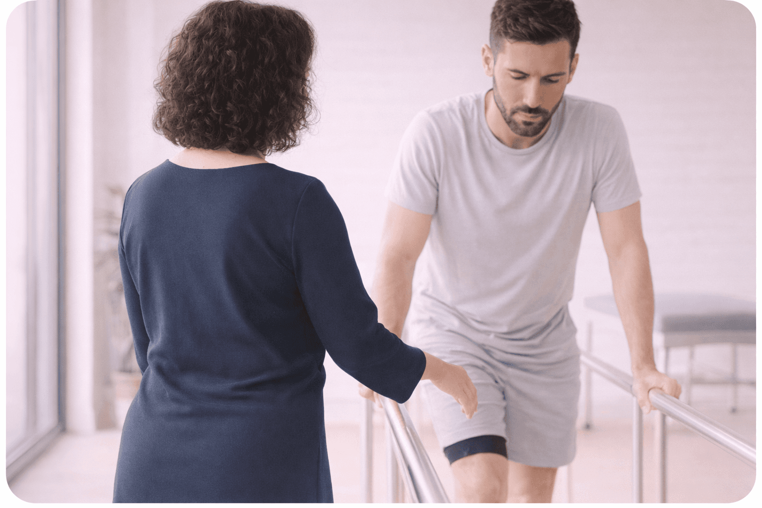 man walking on frame being supervised by doctor