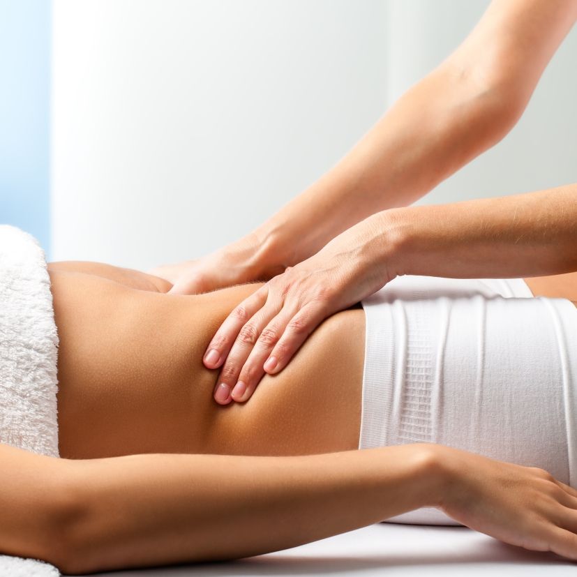 A woman lying down with a towel wrapped around her head, her face glowing with facial oil. She has a peaceful expression, enjoying a skincare treatment.