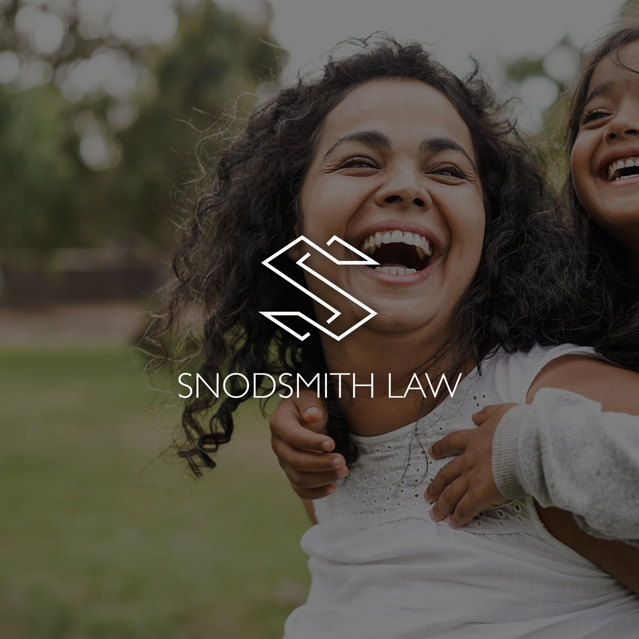 Mother carrying her daughter on her back laughing with the Snodsmith Law logo overlaying the image