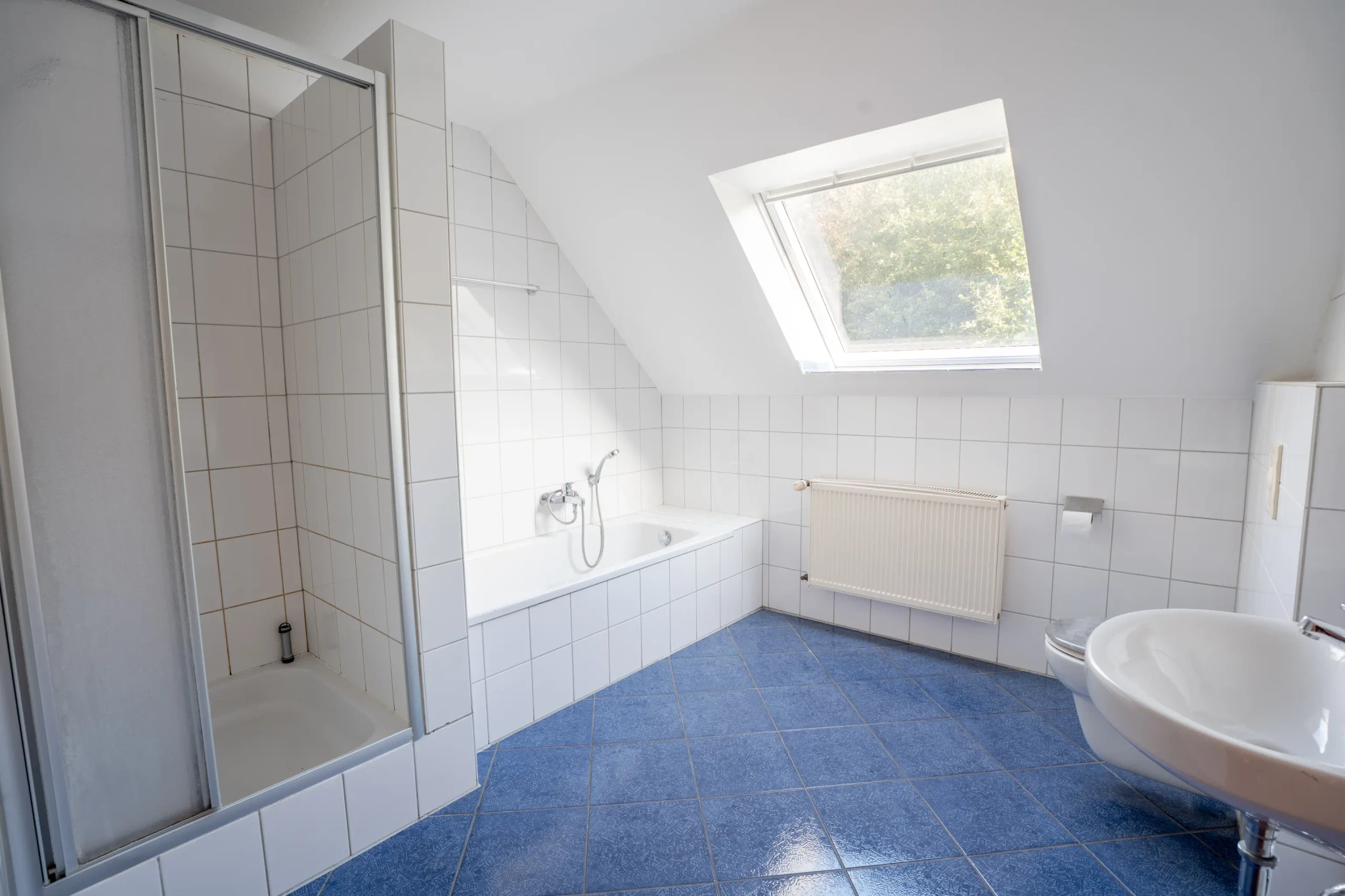 Badezimmer mit Dusche, Badewanne und Dachfenster im Einfamilienhaus in Heek-Nienborg.