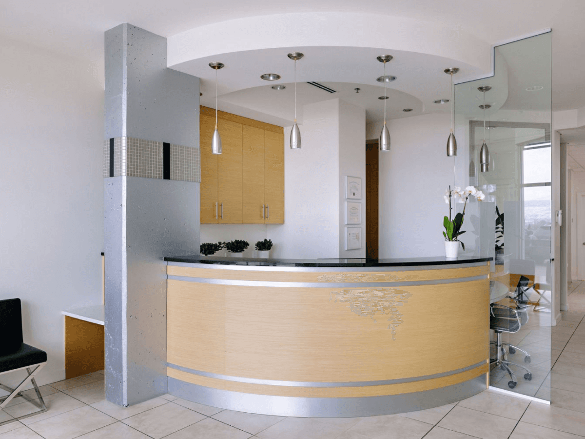 Alpha Dental office reception area with wooden desk and decorative lighting.