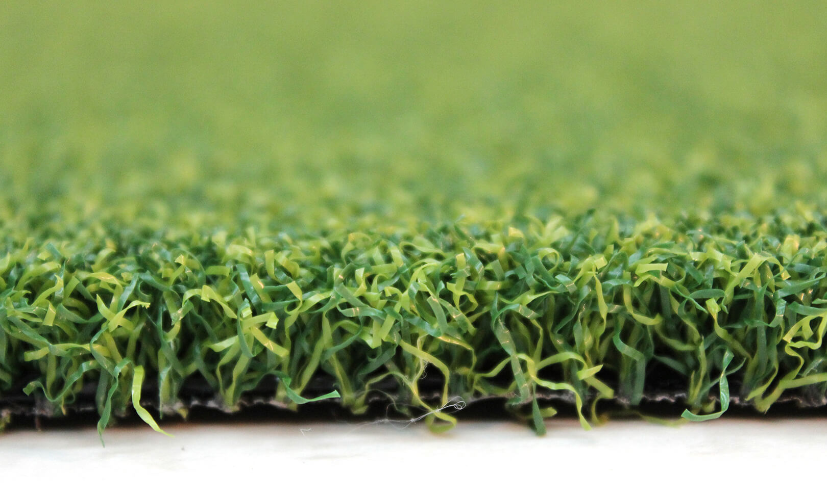 Close-up image displaying the subtle shades of green within AGL Grass North's artificial putting turf for golfers.