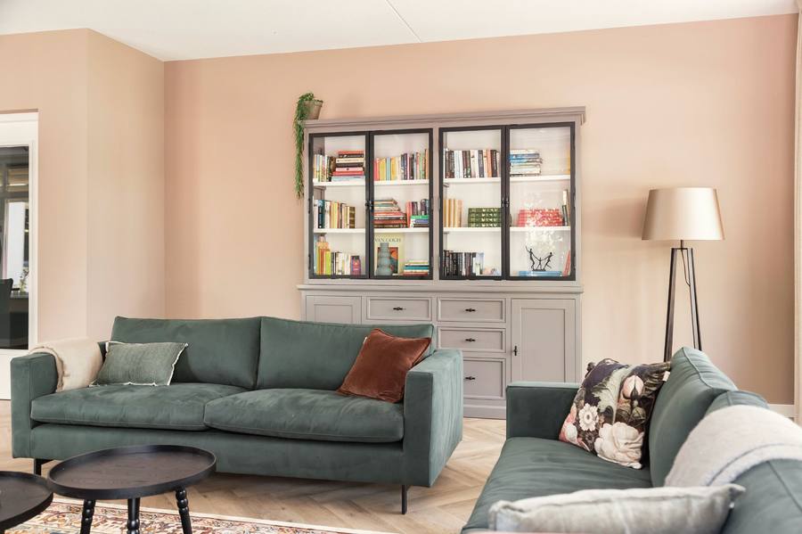 zithoek groene banken en boekenkast grijs 