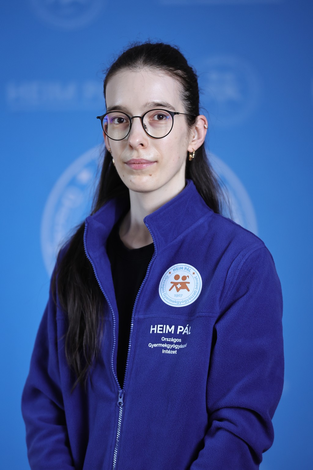 Hosszú barna hajú nő kék kardigánban