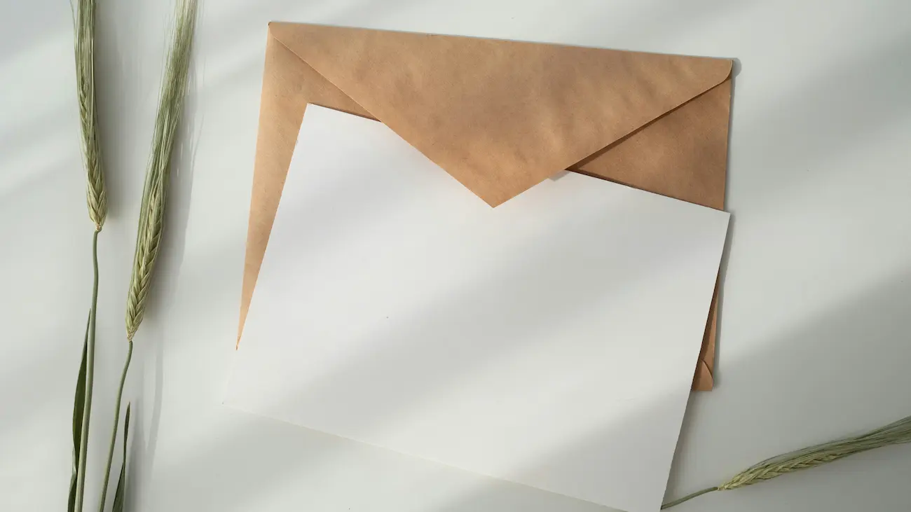 Blank letter and brown envelope on a clean desk, representing a personalised sponsorship outreach letter, email template and professional first contact with potential sponsors.