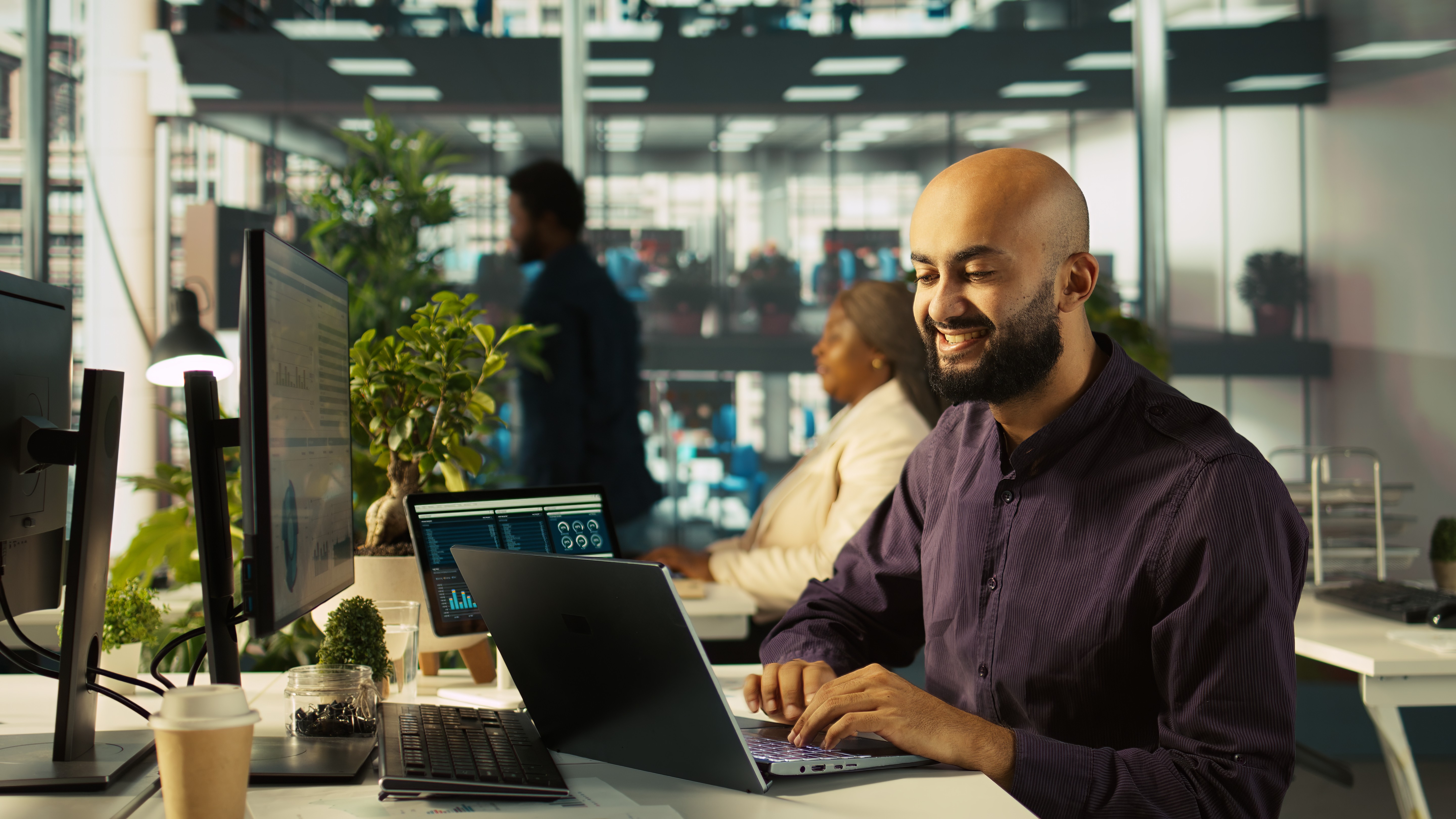 Innendienstler fokussiert am Schreibtisch. er ließt seine Notizen, lächelt leicht und sieht entspannt aus