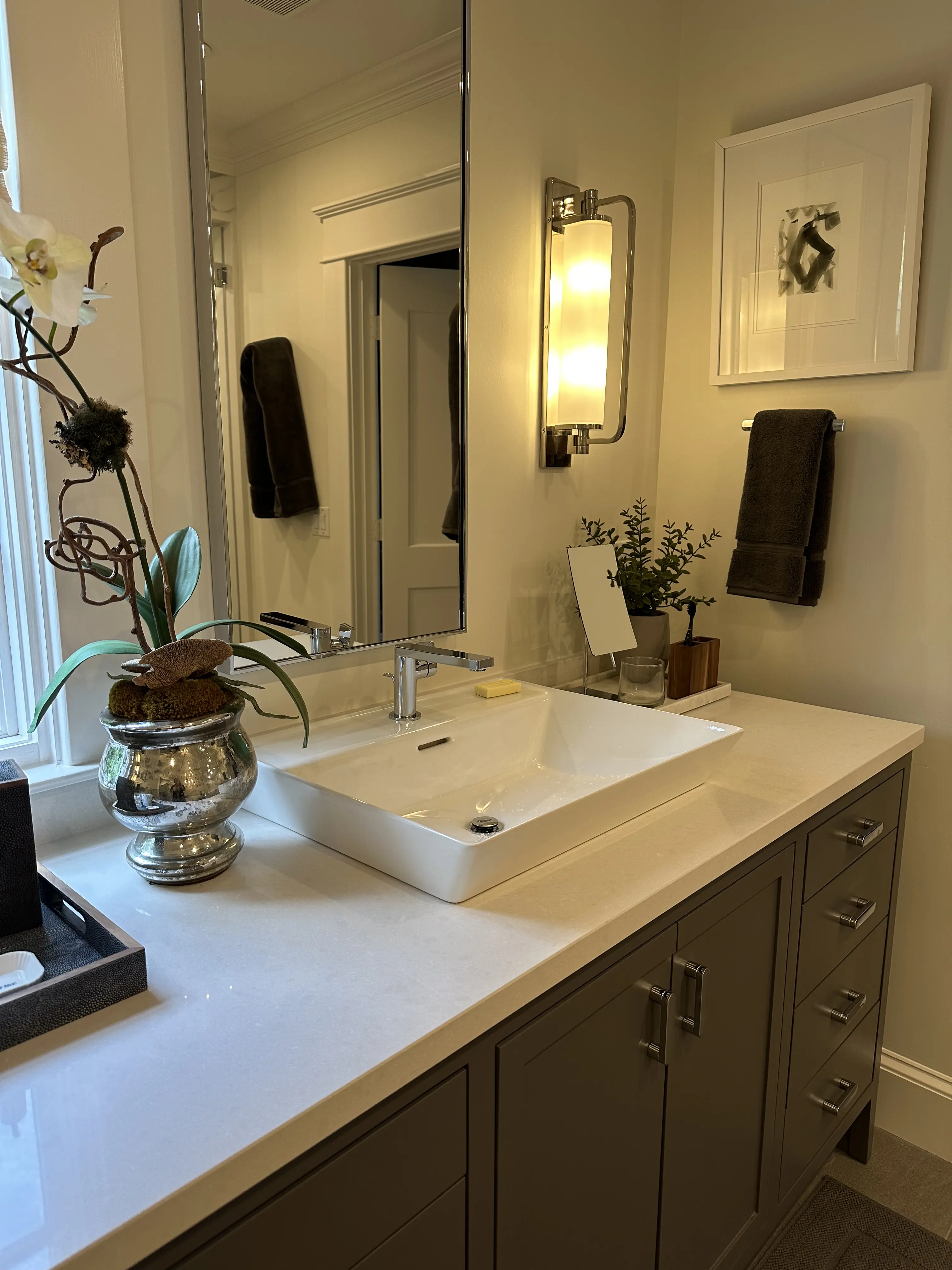 A person in a casual outfit is vacuuming a carpet in a bright, modern living room.