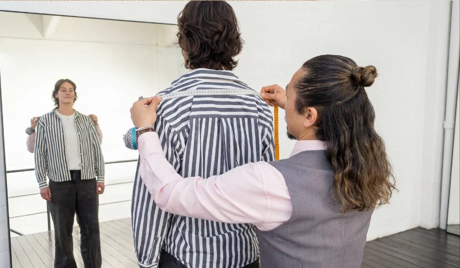 Tailor fitting a bespoke garment on a client at Isadora Nim