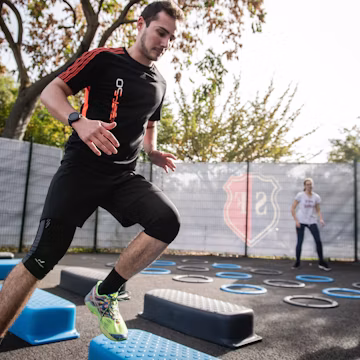 man in black crew neck t-shirt and black shorts running on blue and white trampoline