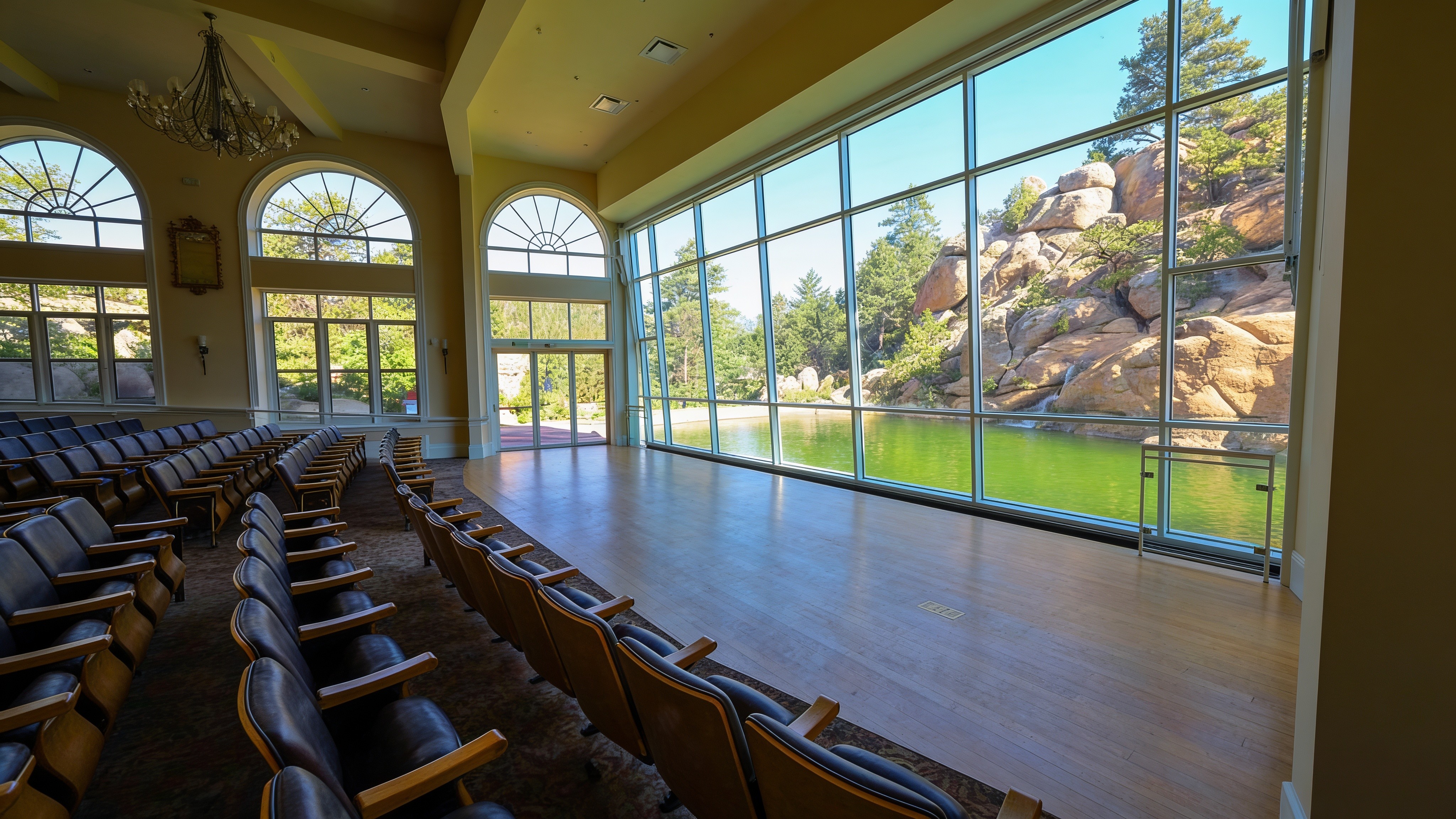 Interior of an event pavilion with floor-to-ceiling glass and mountain views