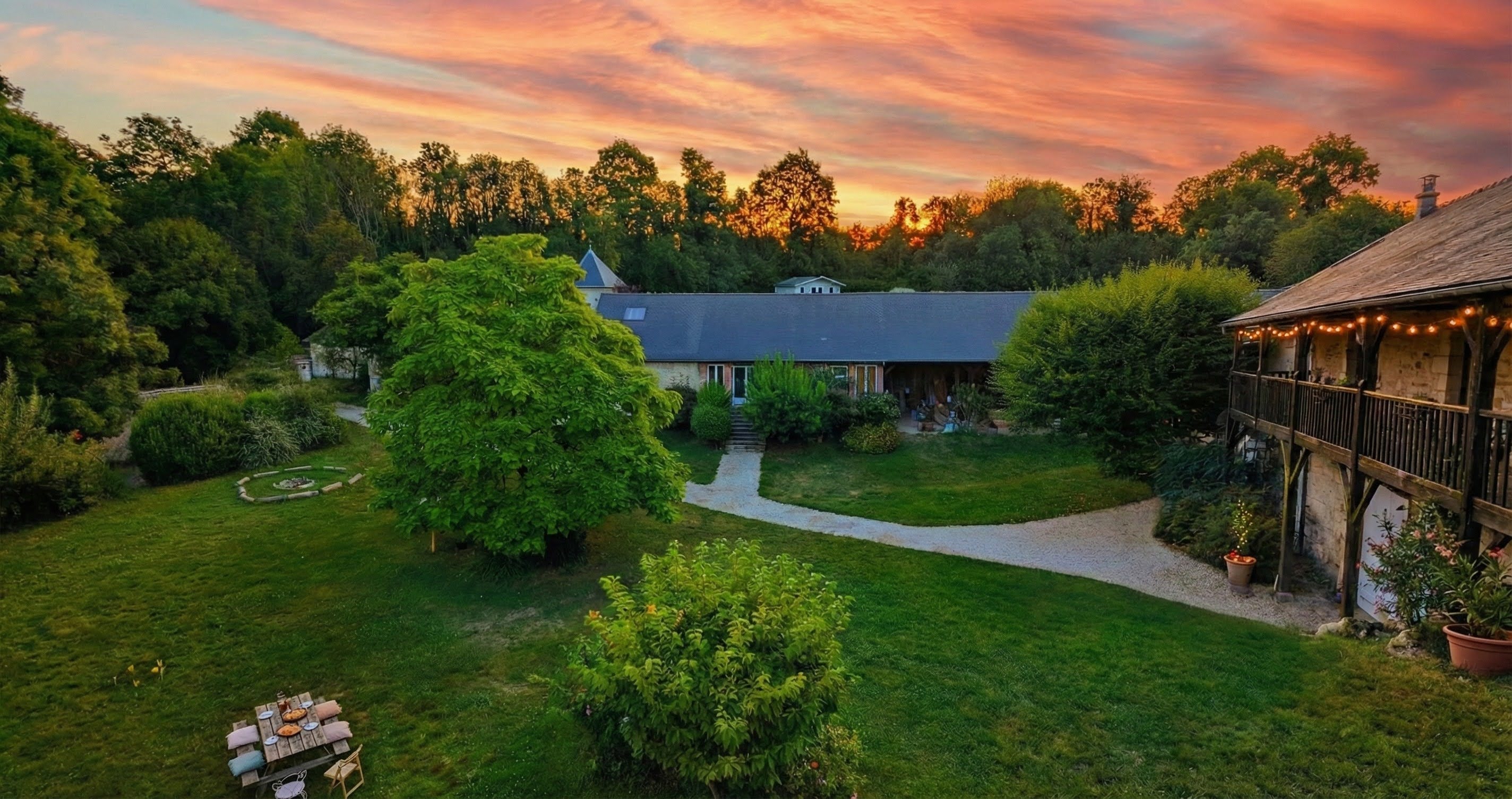 Vue des espaces extérieurs du domaine avec une table confortable pour manger en extérieur, un espace feu de camp et un lieu époustouflant.