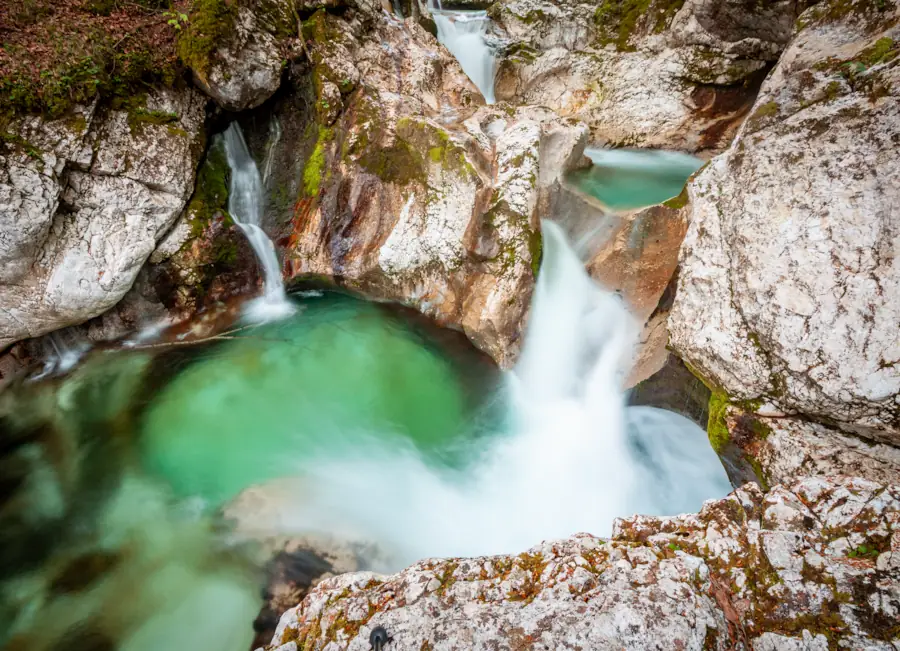 Small cascading waterfalls flowing into emerald pools of clear water at Soča Valley Slovenia.