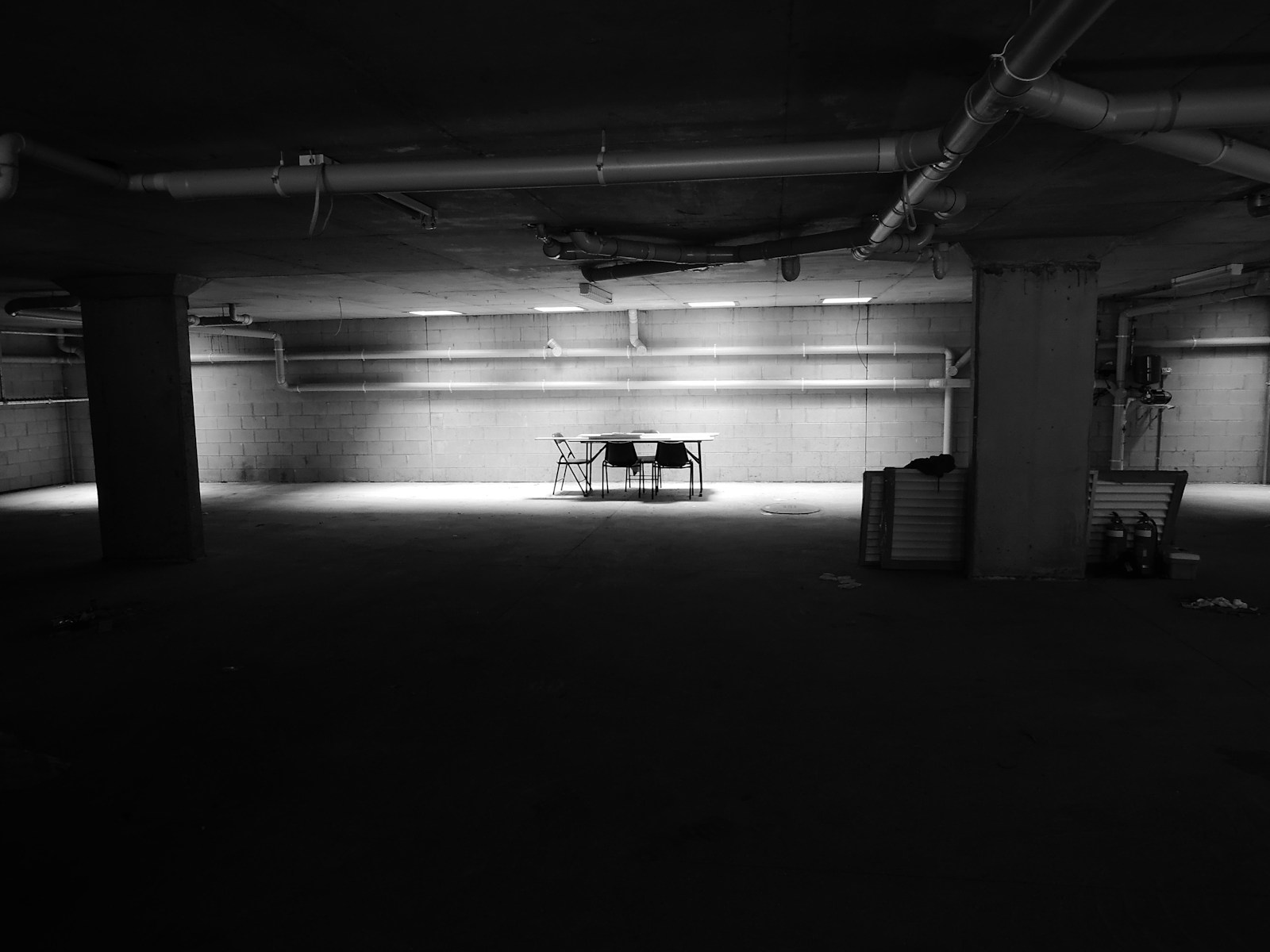 A small dark room with tables and chairs against the wall