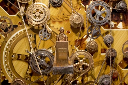 small bust statue with bike gears and chains in the background