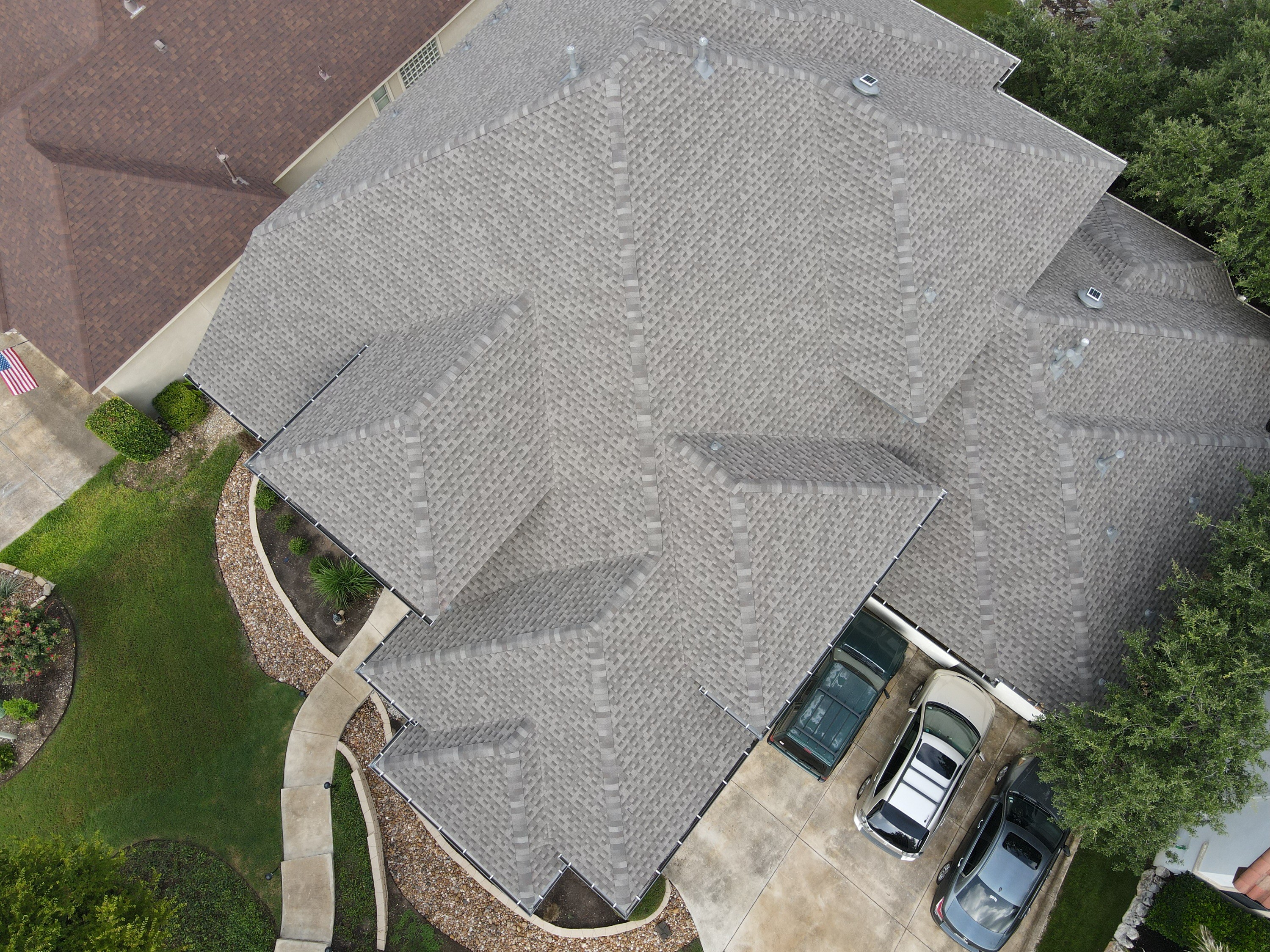 Drone view of a roof with several hips and valleys. Measure the actual roof and complexity before comparing replacement prices.