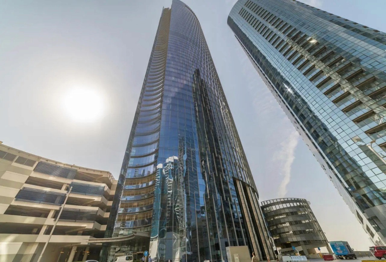 Close-up of the glass exterior of a luxury commercial building in a bustling business district.
