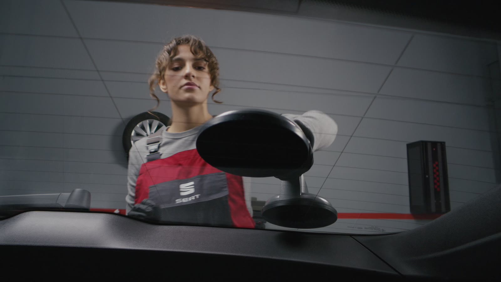 SEAT workshop video frame showing a technician working on the windscreen, directed by PHOCUS