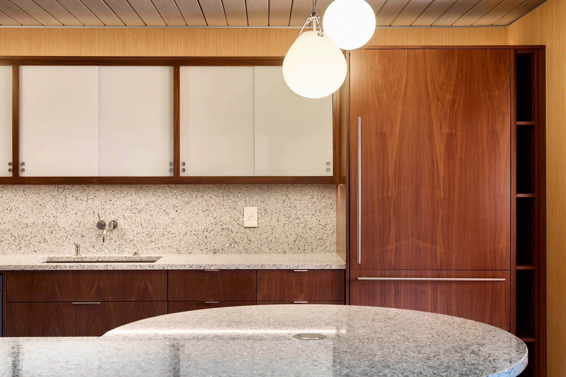 Wide shot of the kitchen with a straight view, highlighting the sleek design and bold use of color in this Eichler home remodel. Photo by Todd Huge.