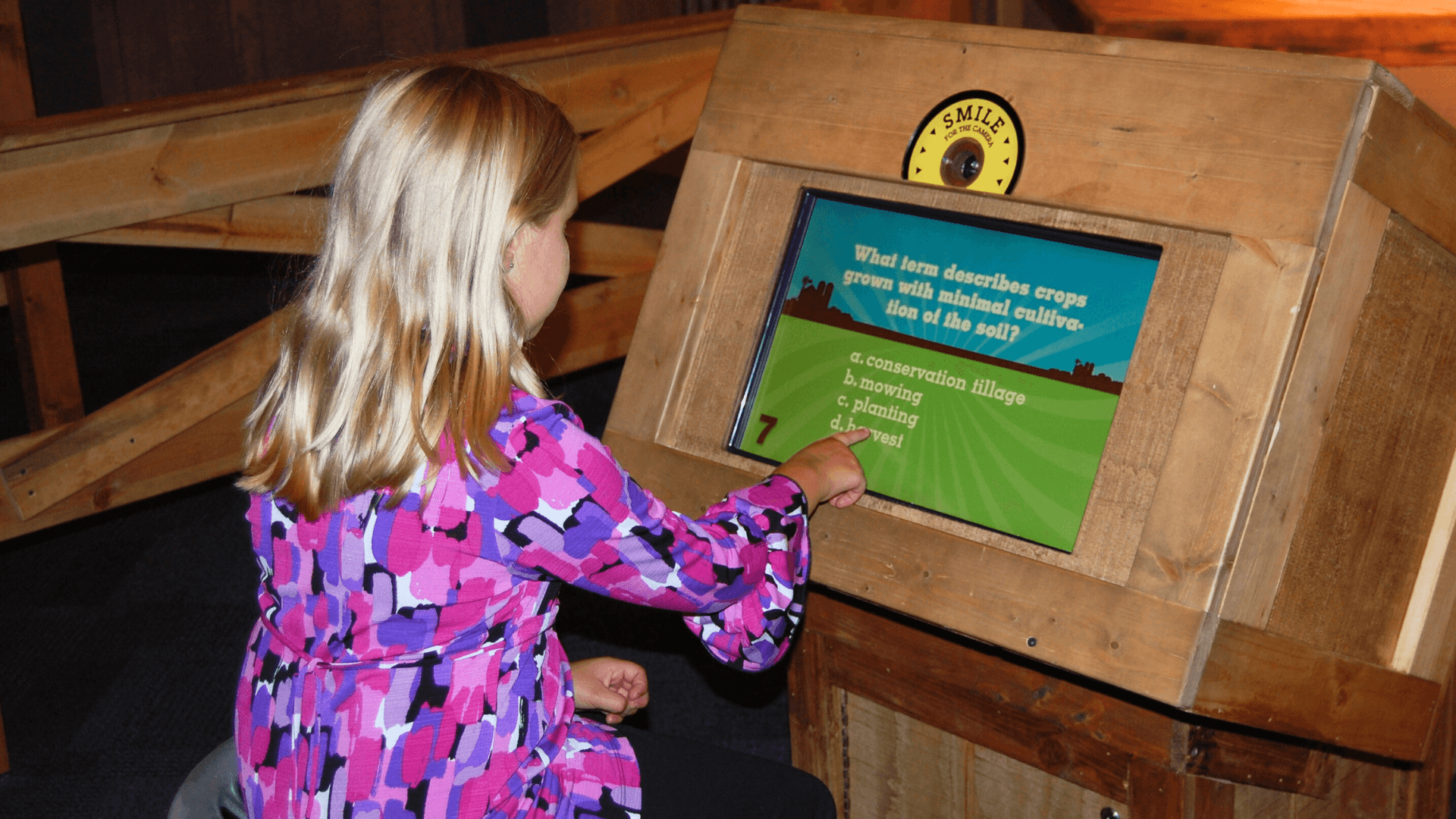 A young girl starts playing Farm 101 by answering a multiple choice question.