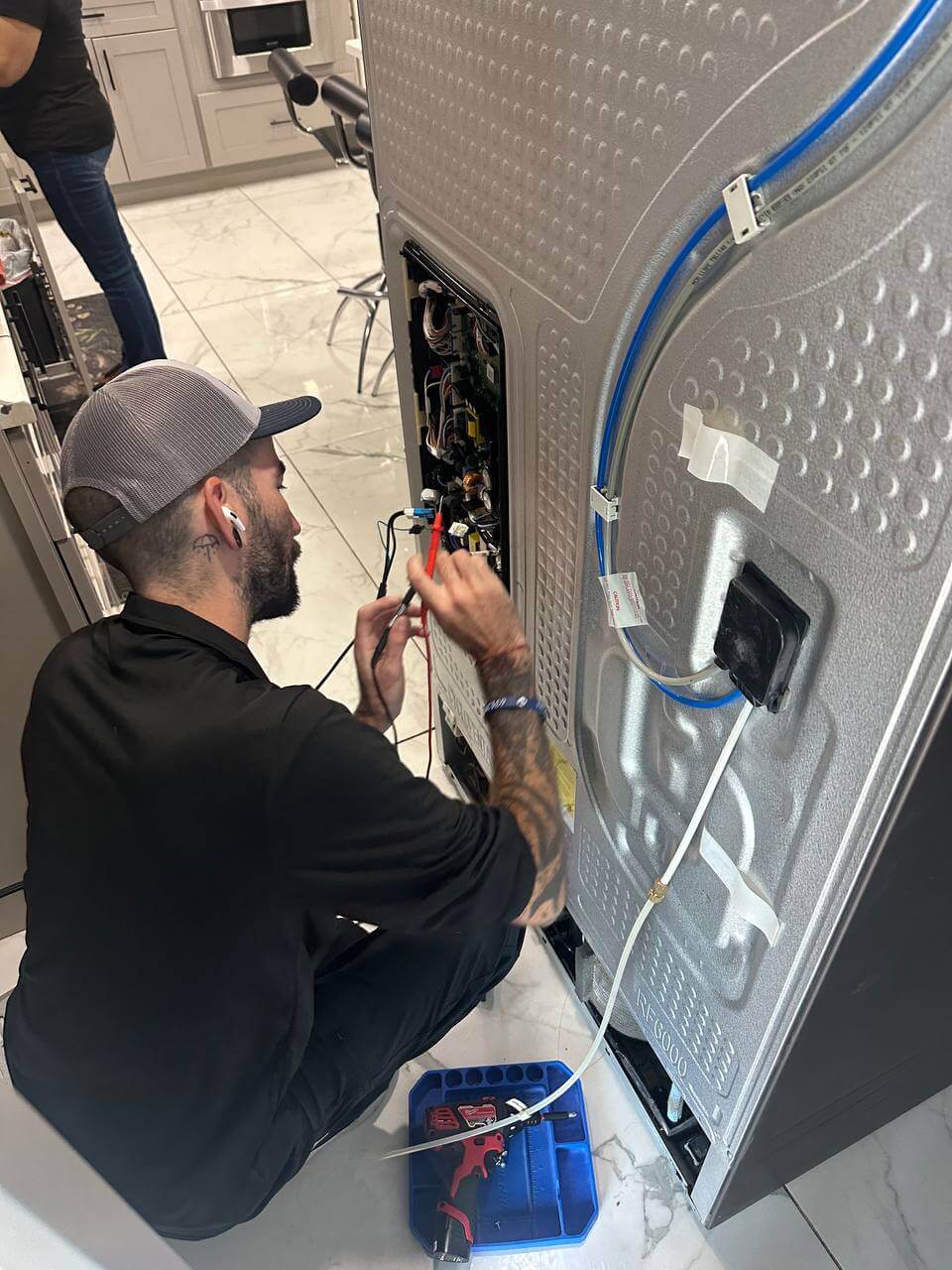 JIC worker repairing a refrigerator