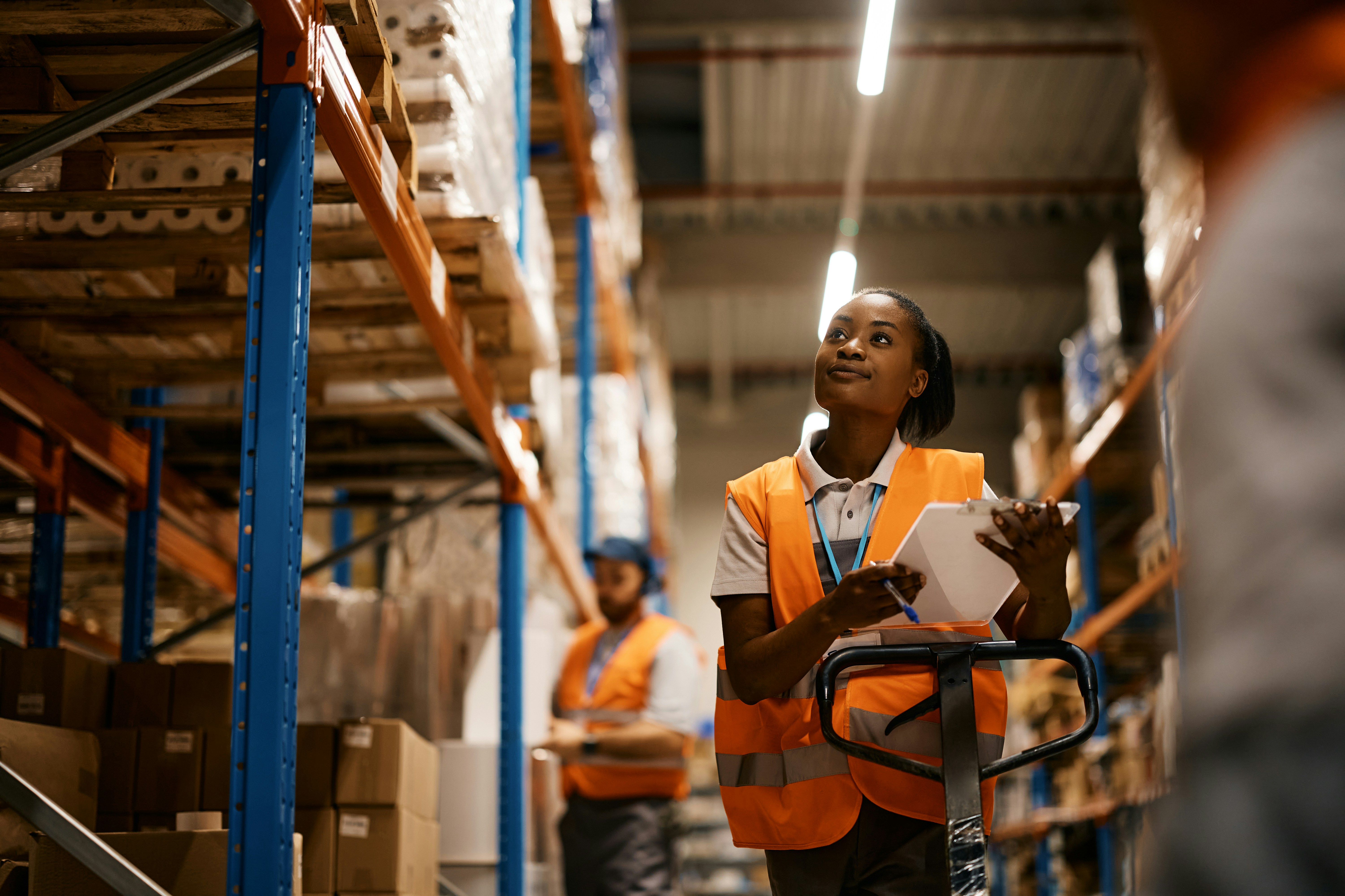 warehouse worker looking up at some shelves