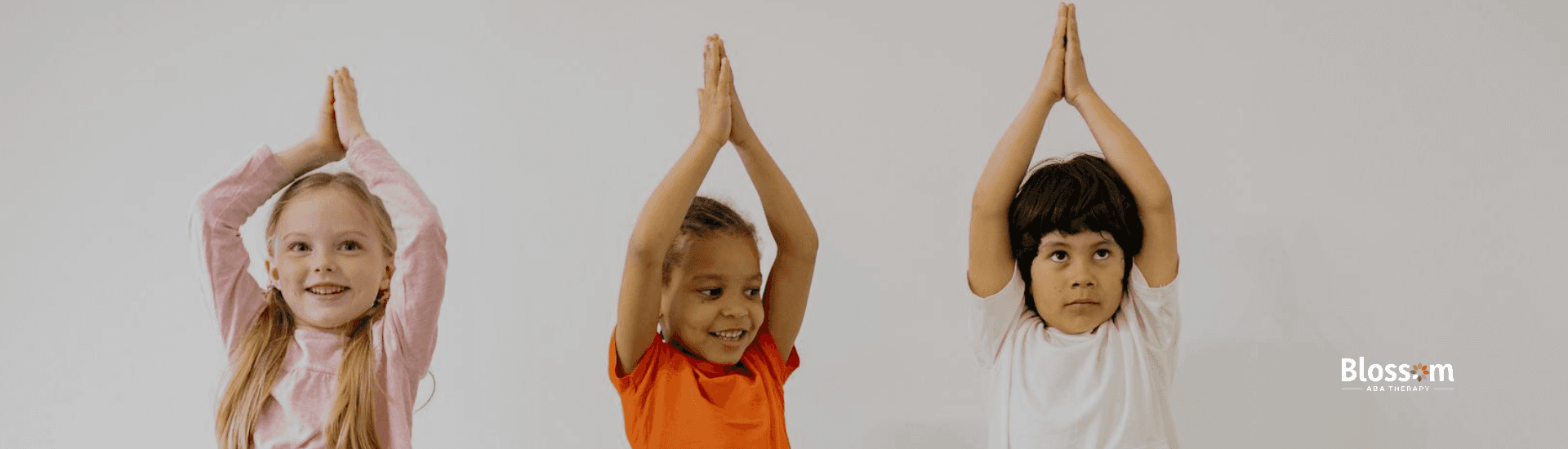 Three autistic children practicing yoga together, smiling and balancing on one leg in Tennessee.