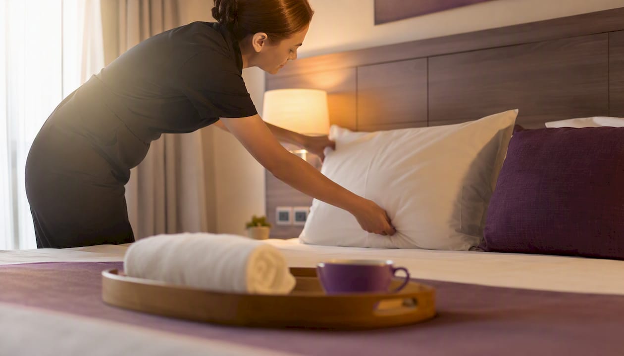 Hands arranging towels in hotel room