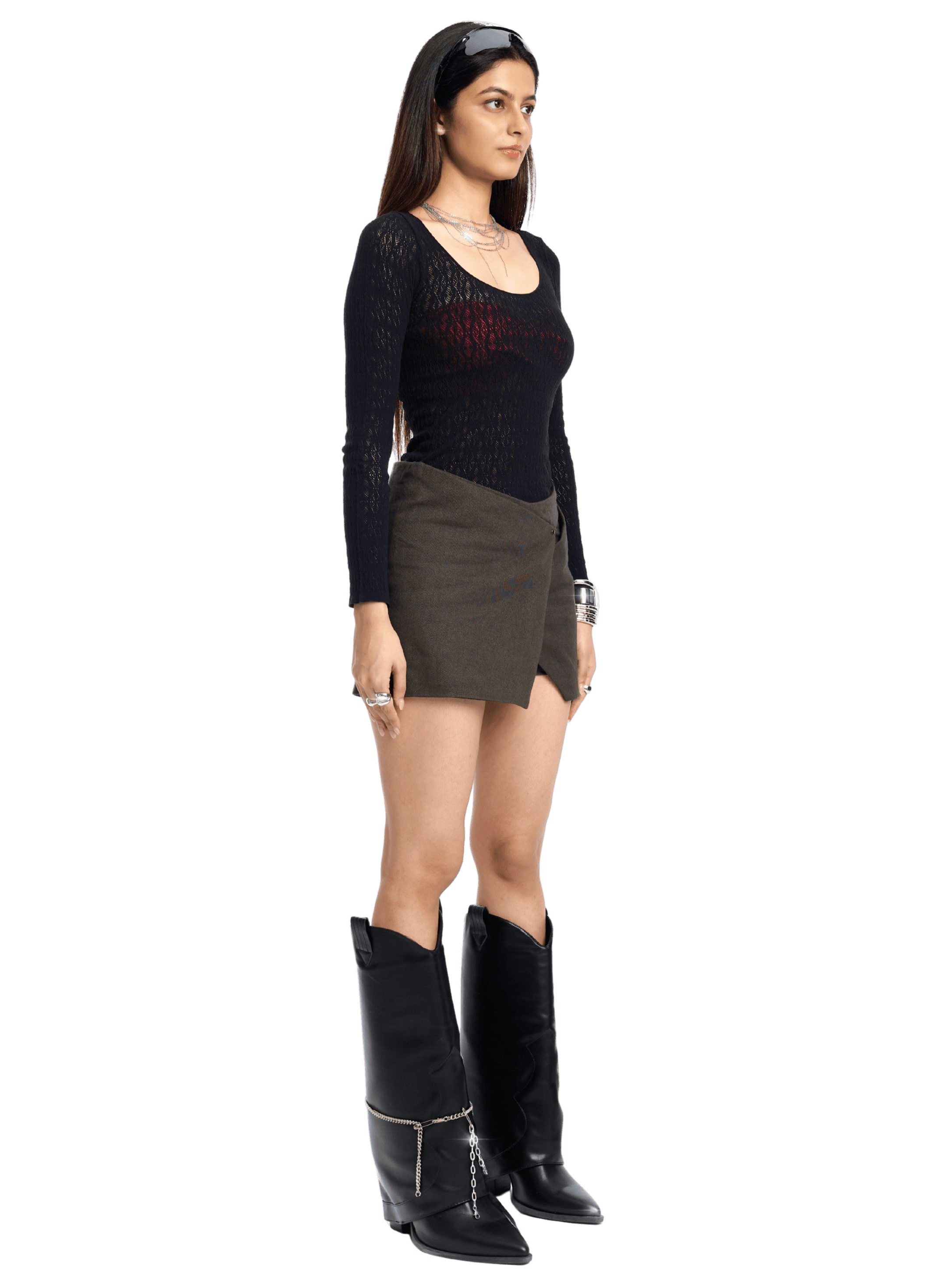 Woman wearing a black top, brown skirt, and black boots on a white background
