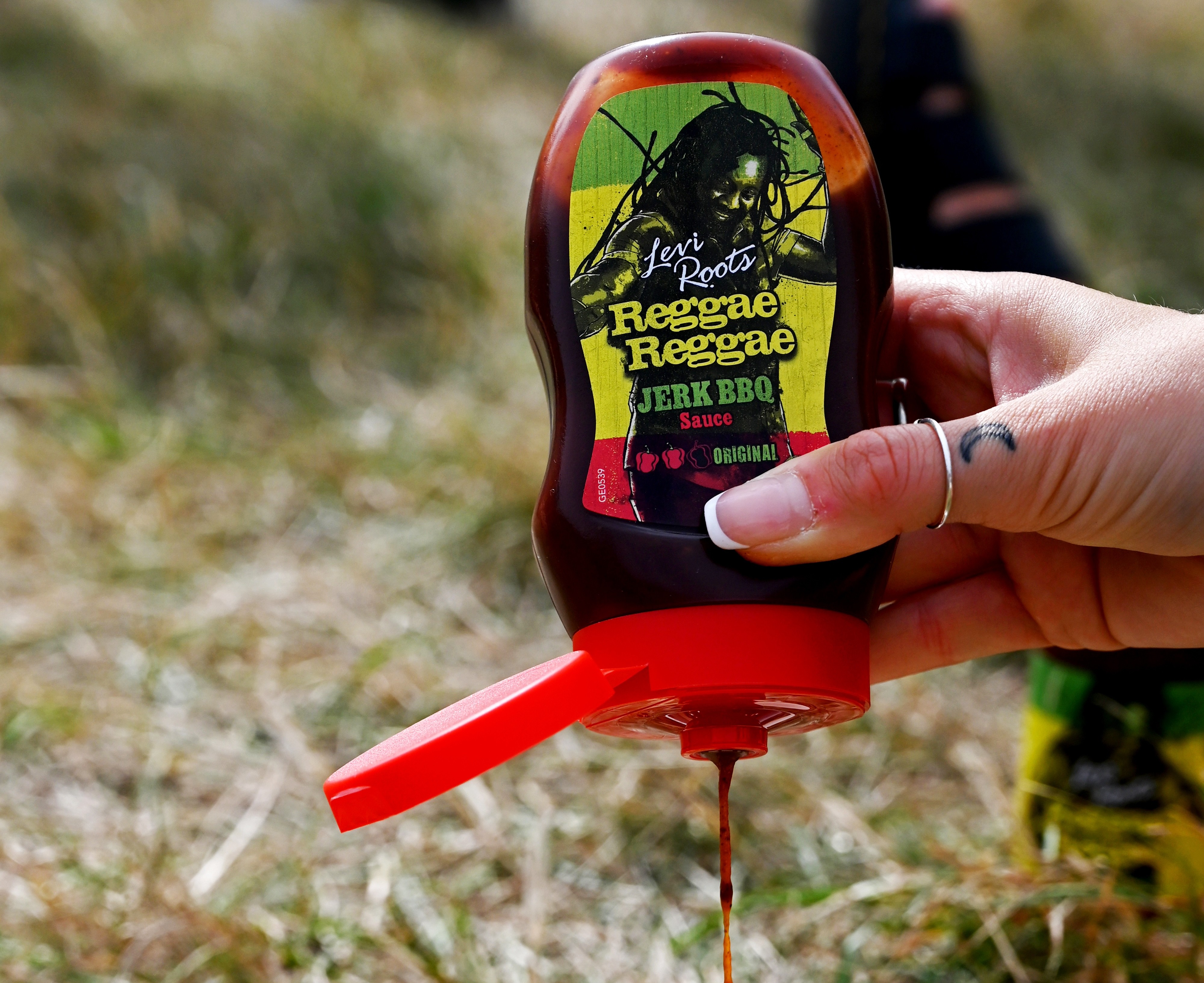 A bottle of Levi Roots Reggae Reggae Sauce being poured onto food