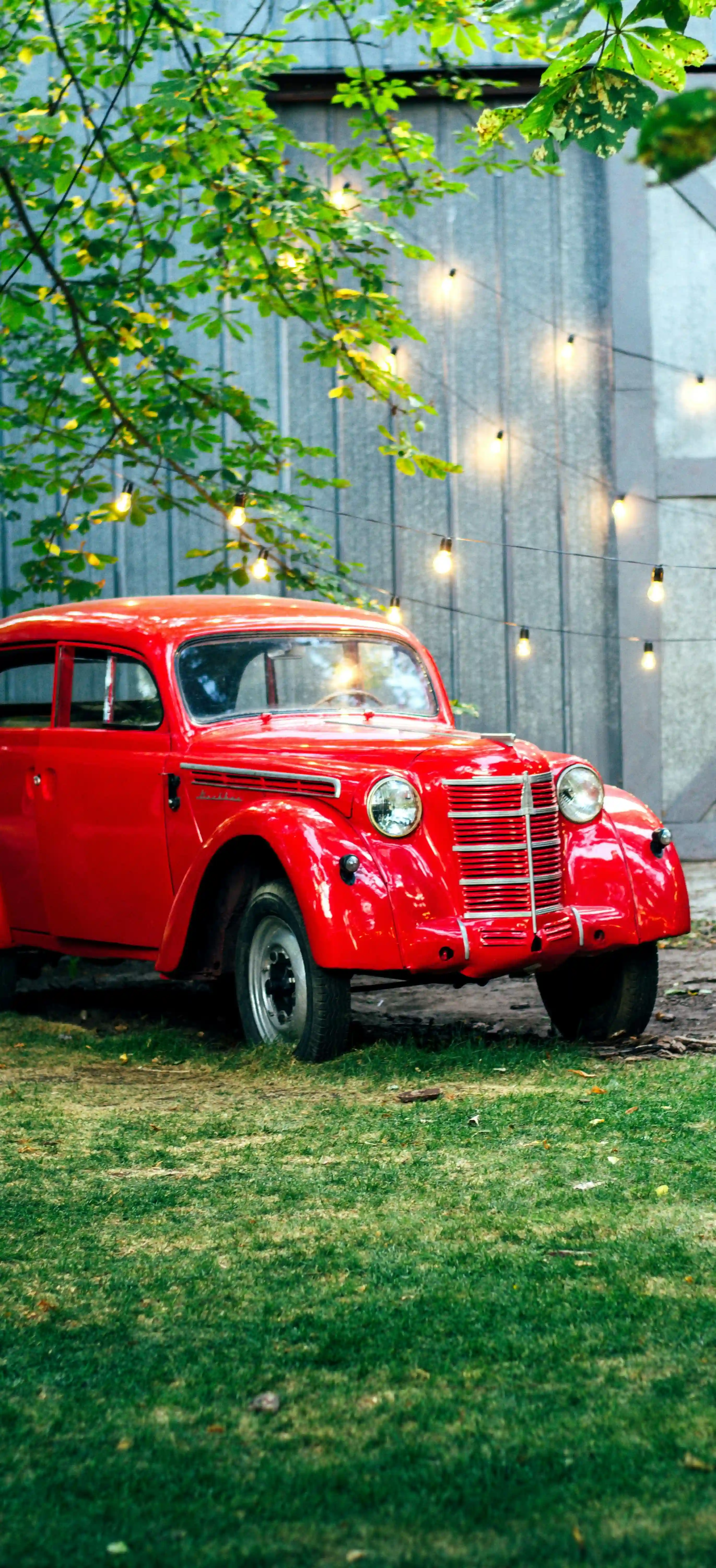 red vintage car parked on green grass field