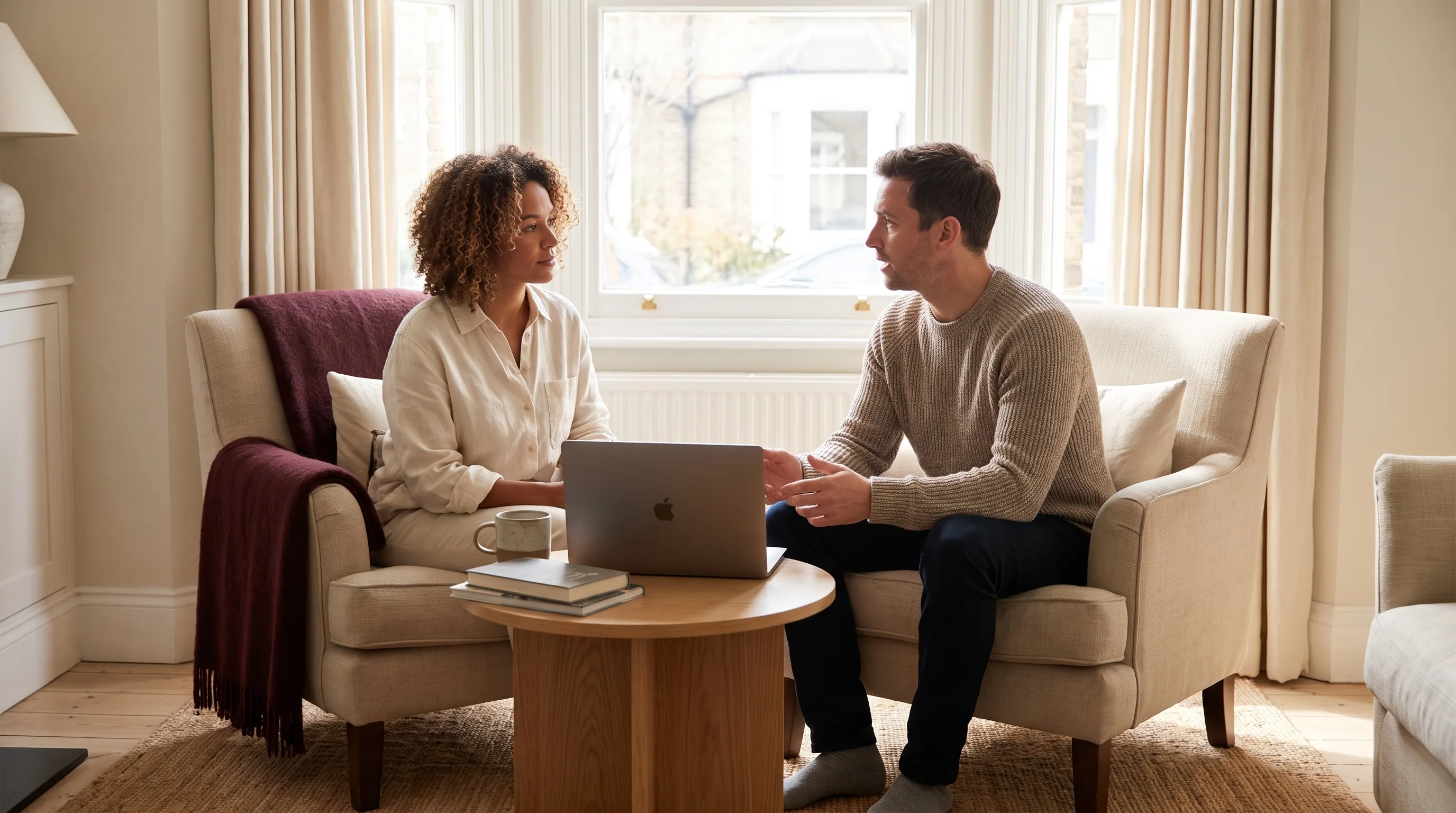 Two people in an in-person session with a MacBook capturing the conversation locally