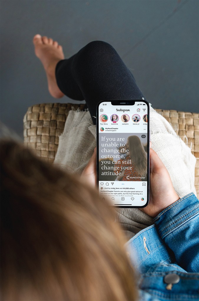 Woman holding phone looking at My Next Chapter post on Instagram